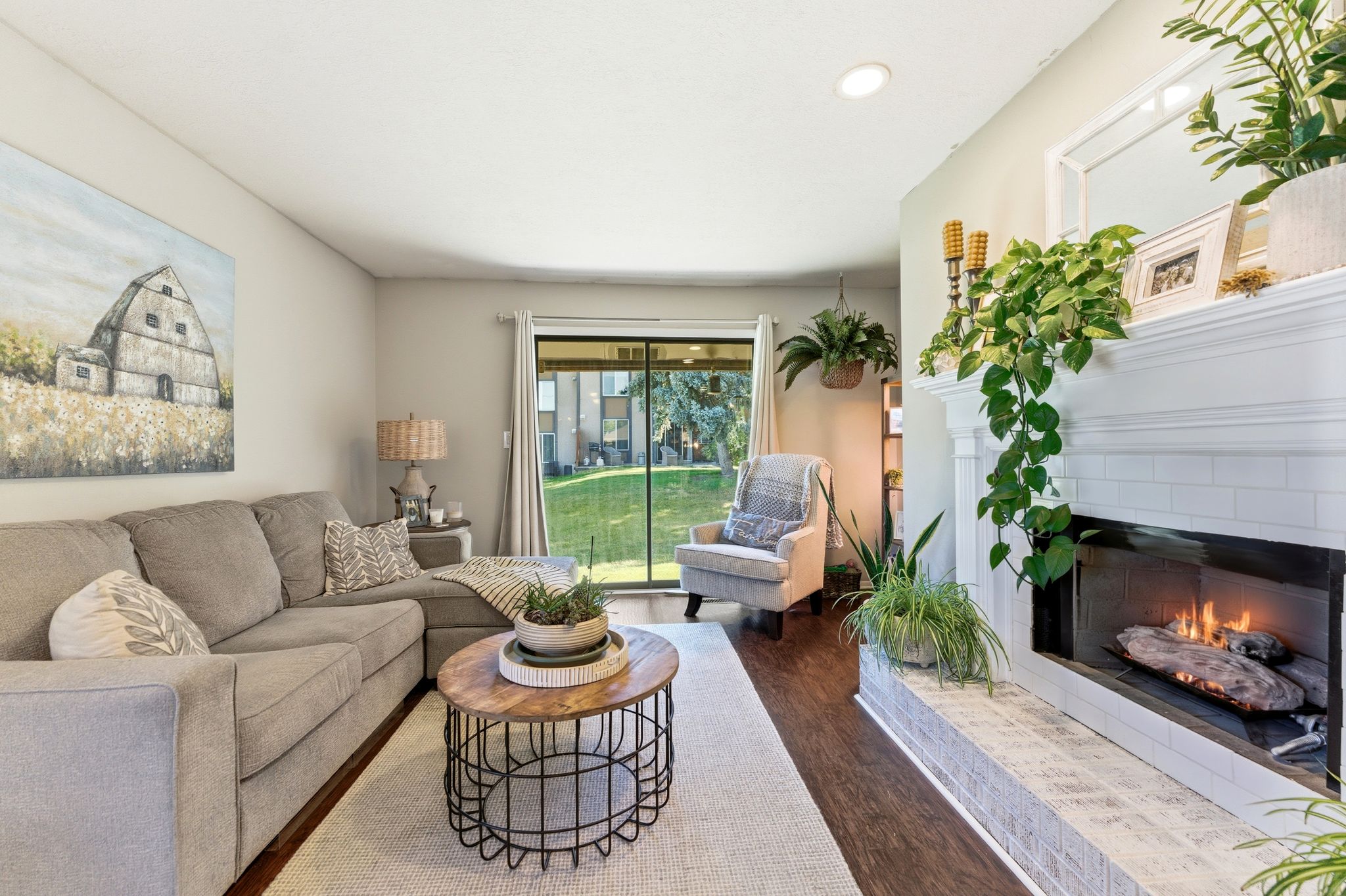 Spacious living area featuring a white subway tile fireplace with a substantial hearth, wood-finish flooring, and recessed lighting