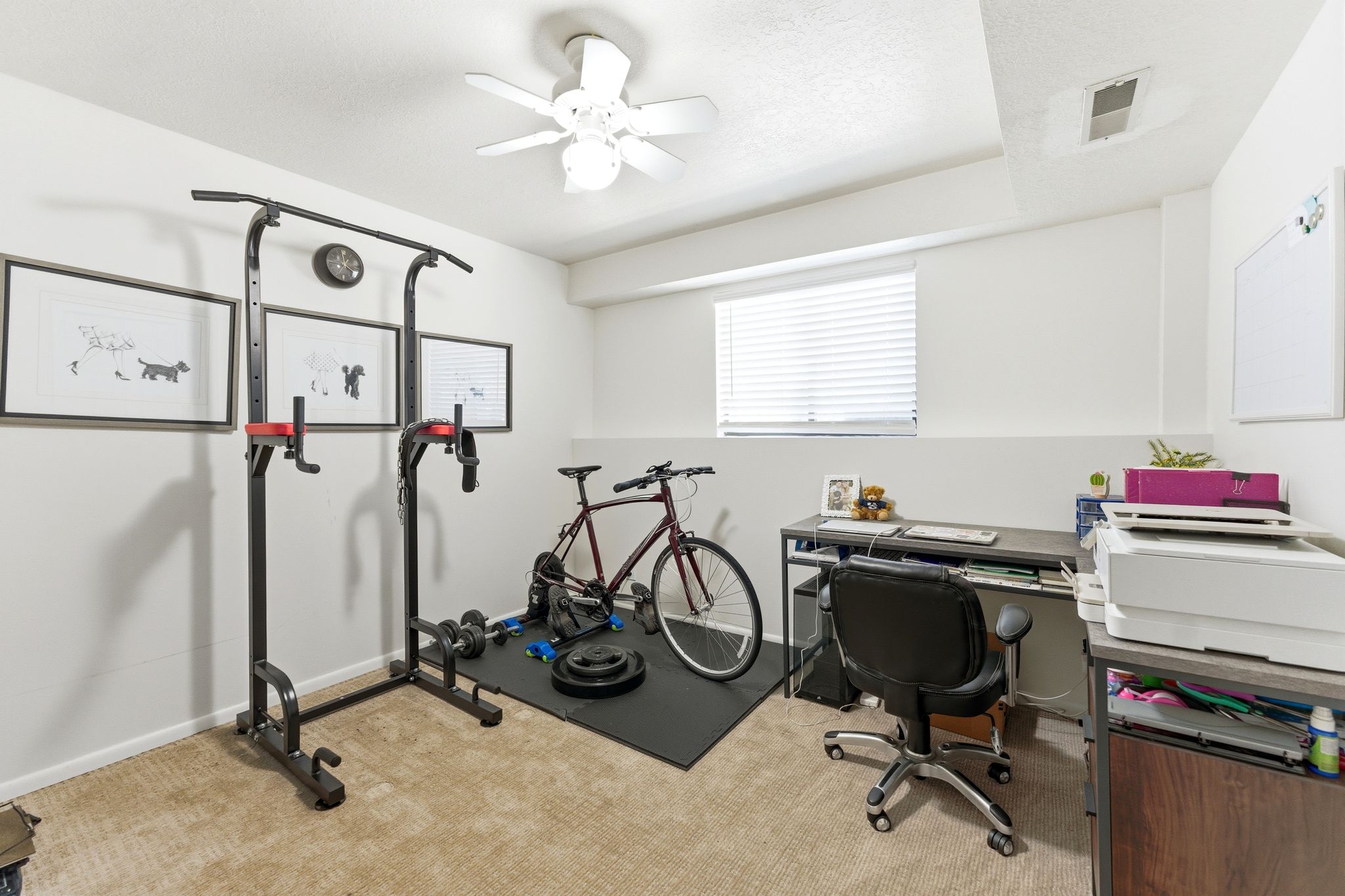 Carpeted room featuring a ceiling fan, a window with blinds, and white walls