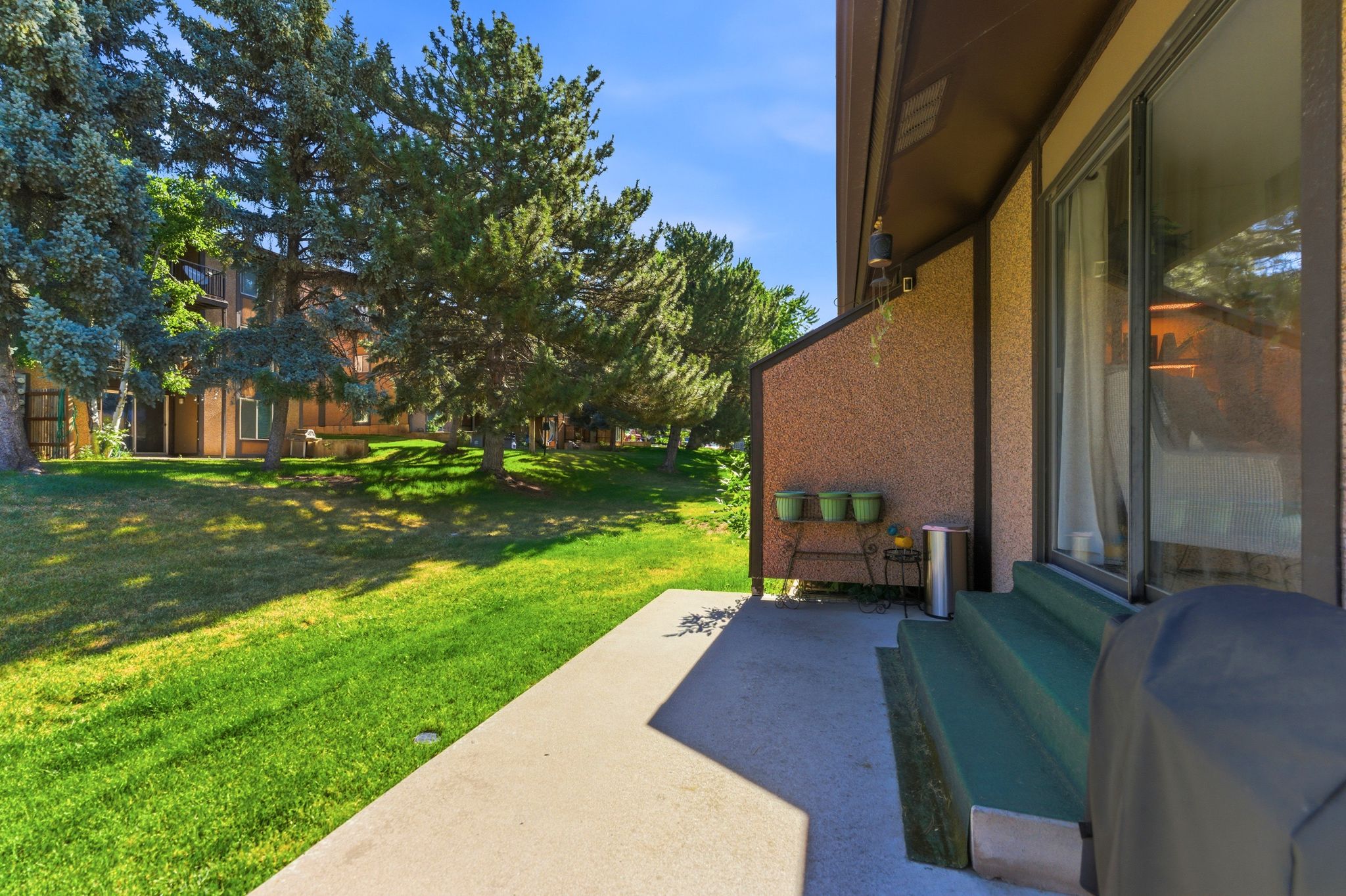 Private ground-level patio with steps leading to a sliding glass door