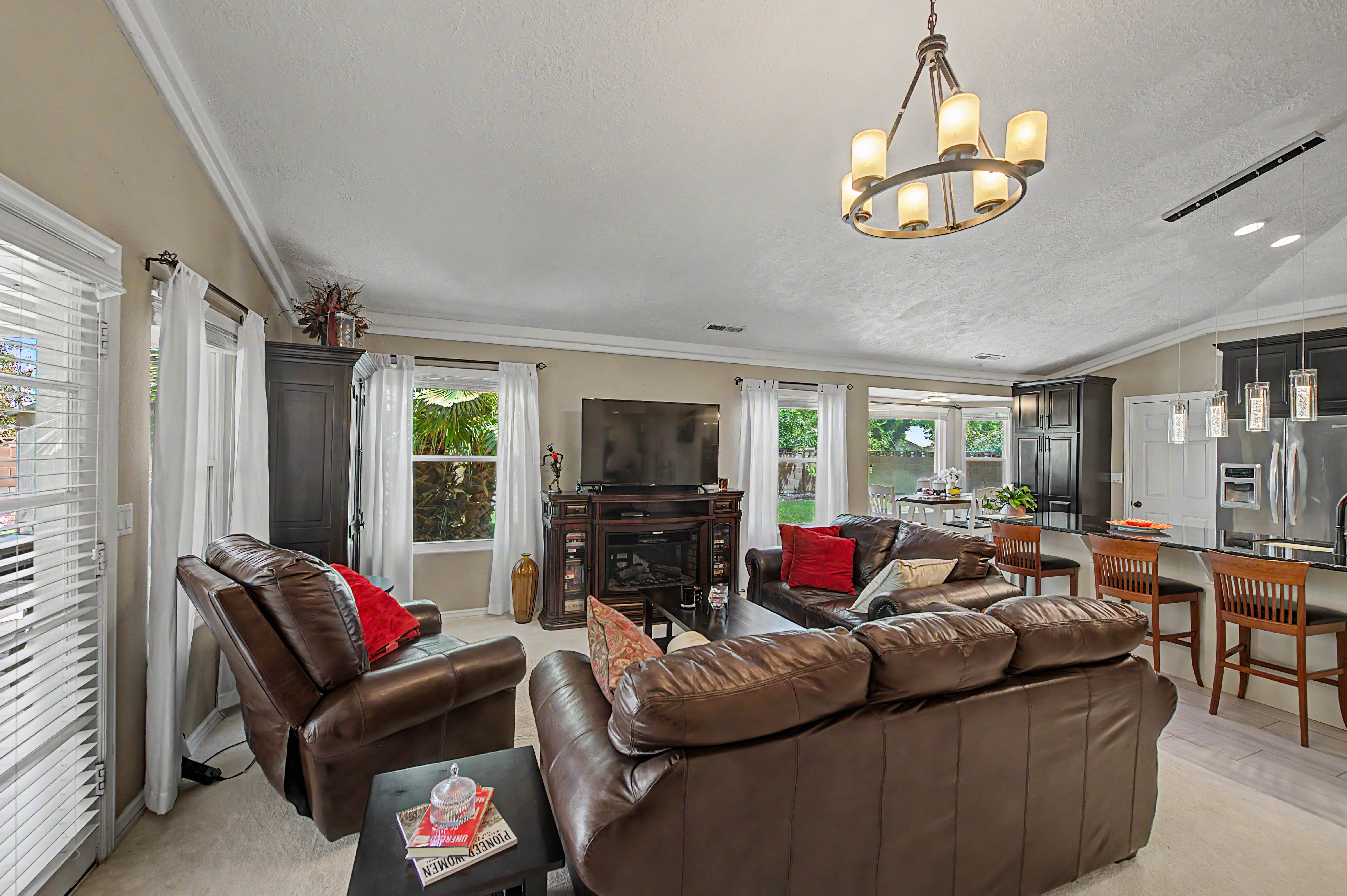 Open-concept living space featuring crown molding, a built-in electric fireplace, and light-tone wall paint
