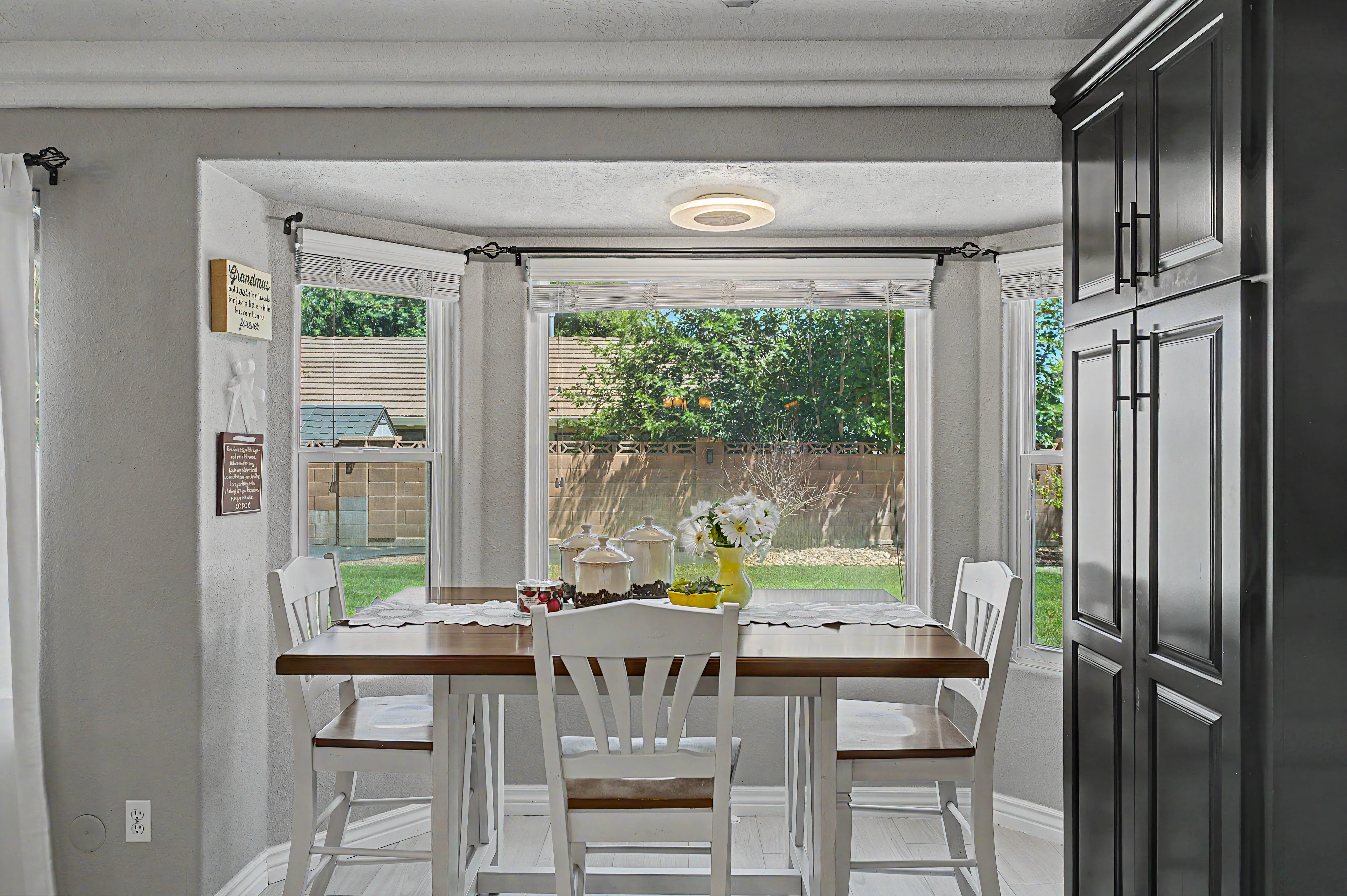 Bay window dining area with natural light and a backyard perspective