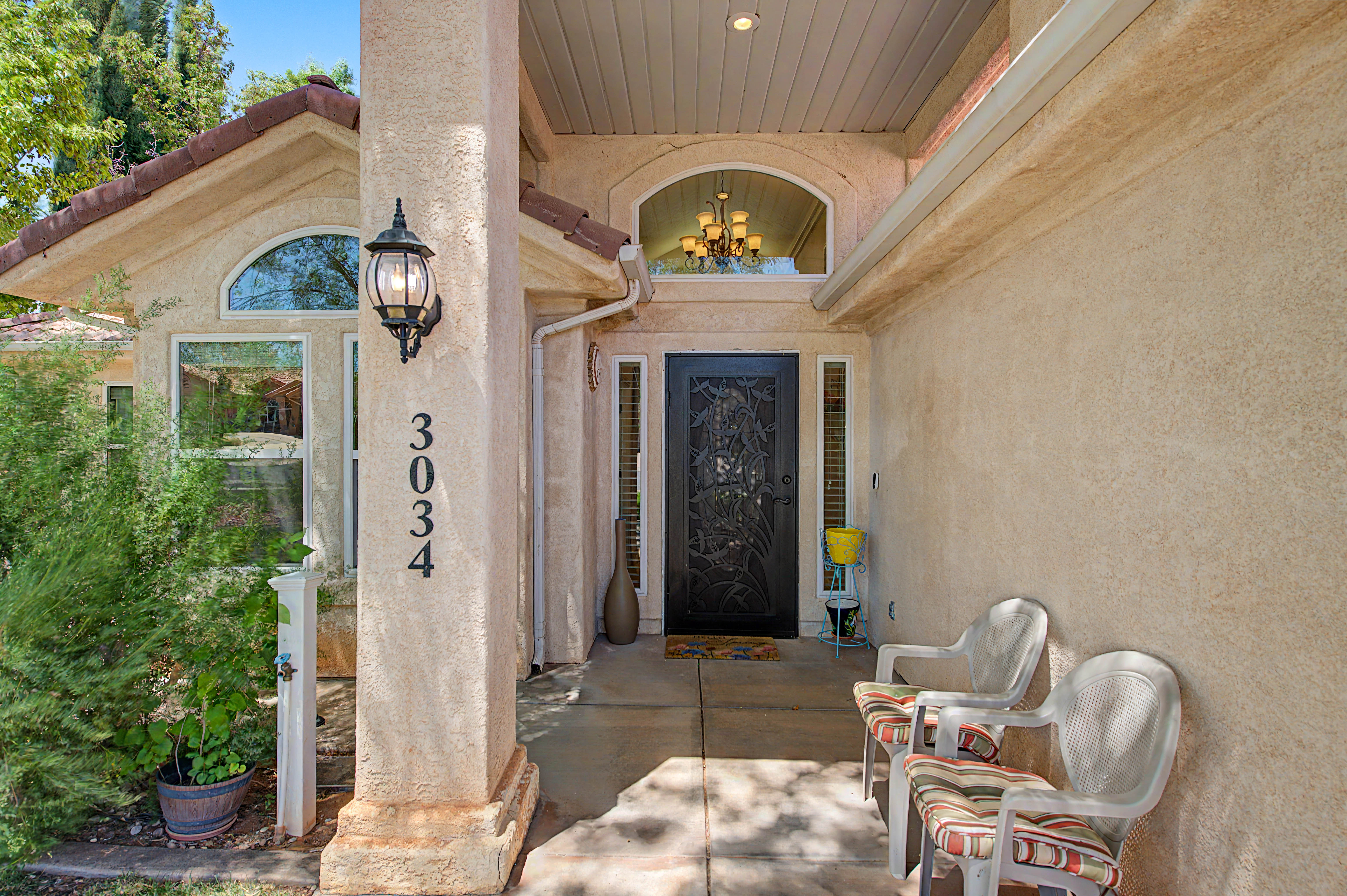 Stucco exterior with arched windows and a covered entry