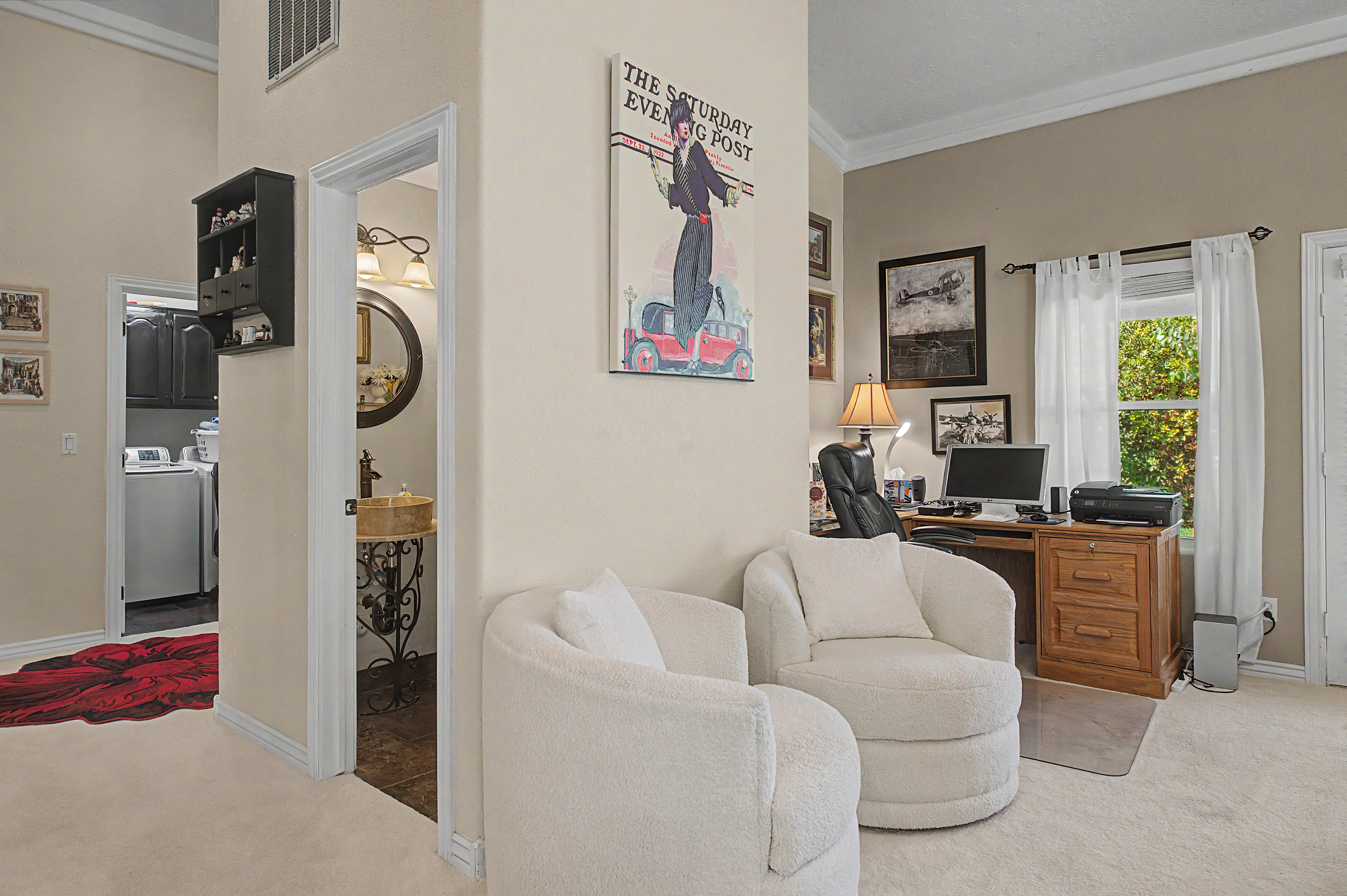 Carpeted interior space featuring a built-in wooden desk, a window offering natural light, and crown molding