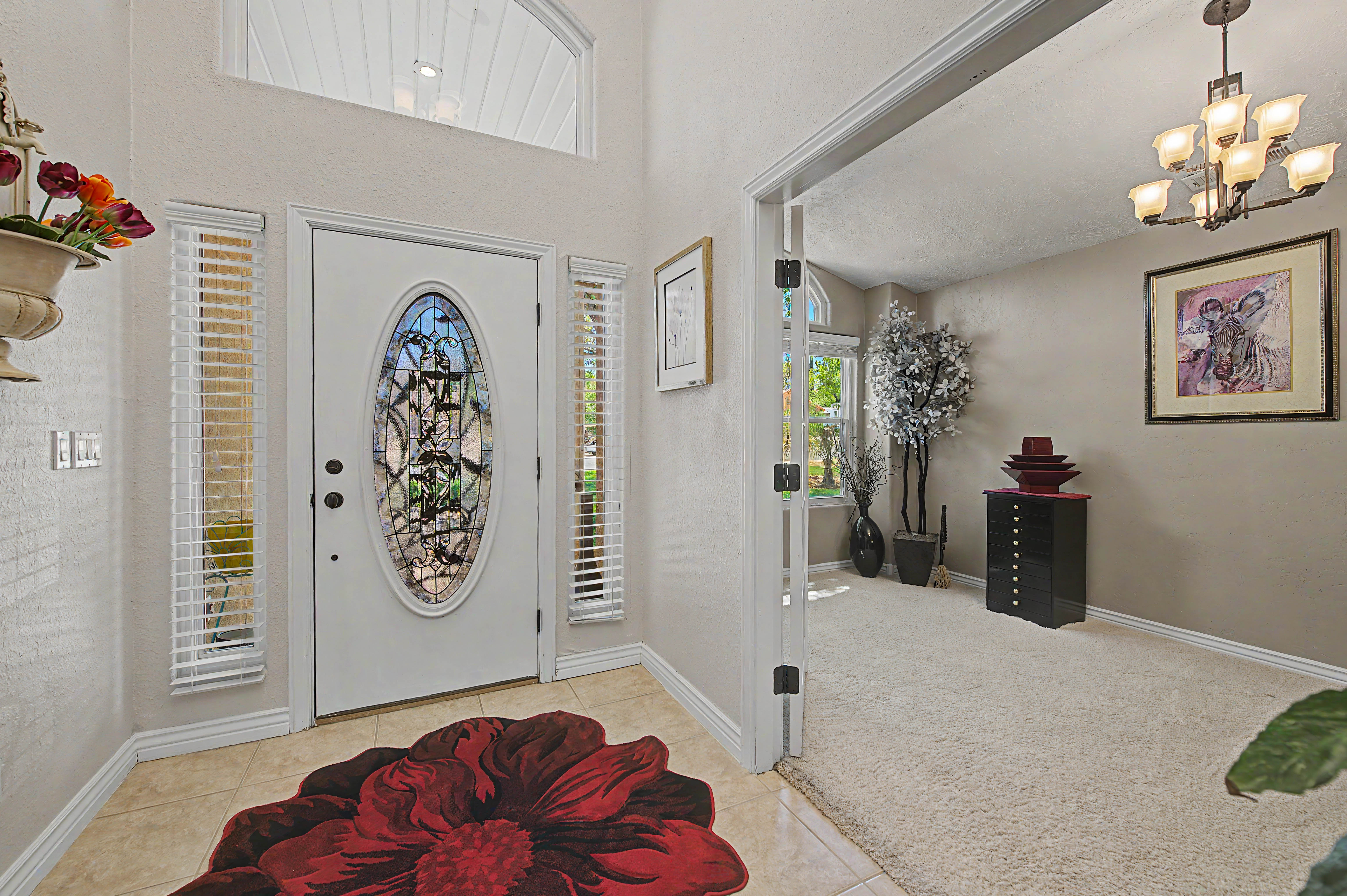 Entryway with a decorative oval glass door, sidelight windows, and an arched transom window