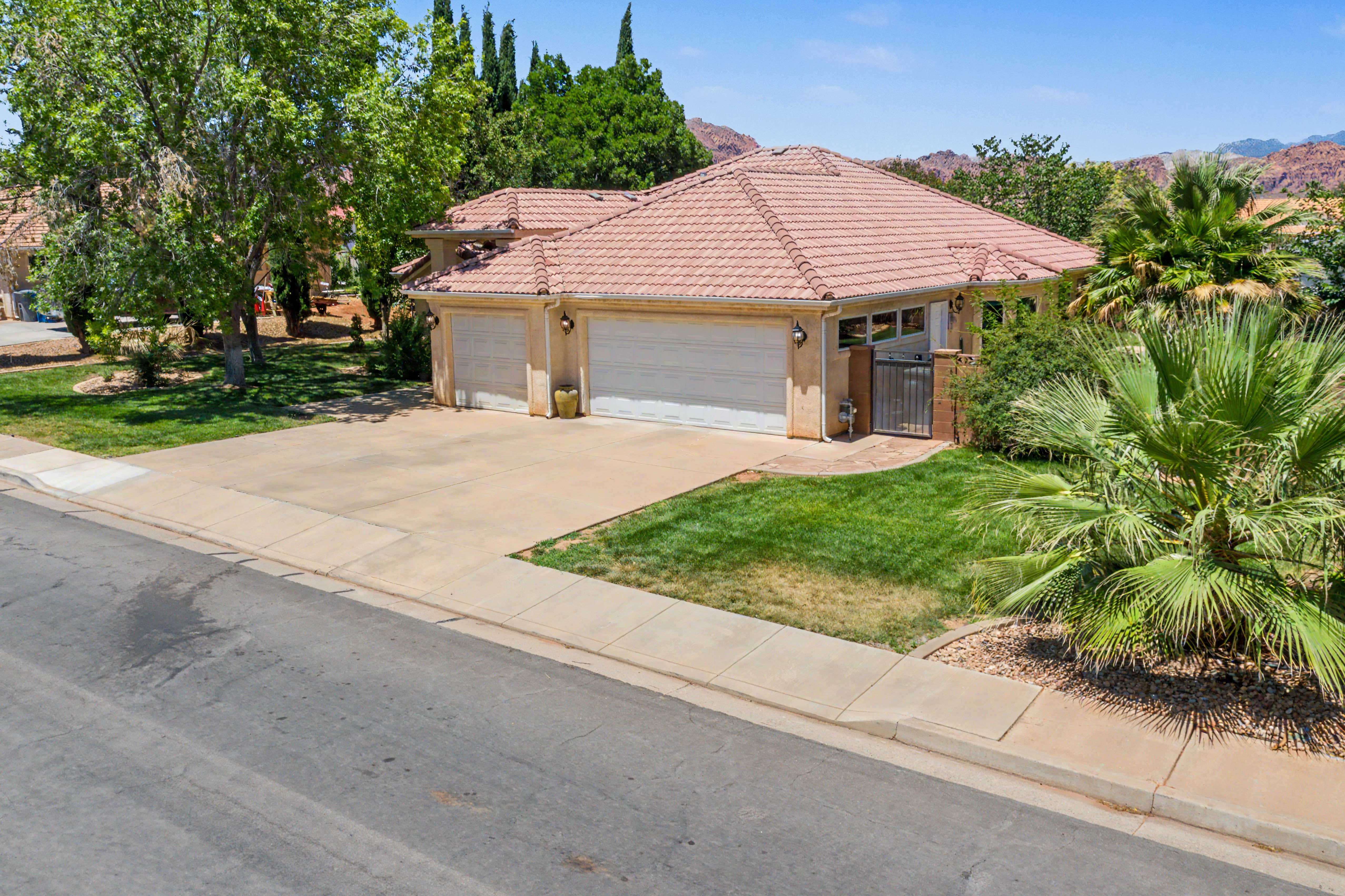 Single-story residence featuring a tile roof, an attached two-car garage, and a concrete driveway