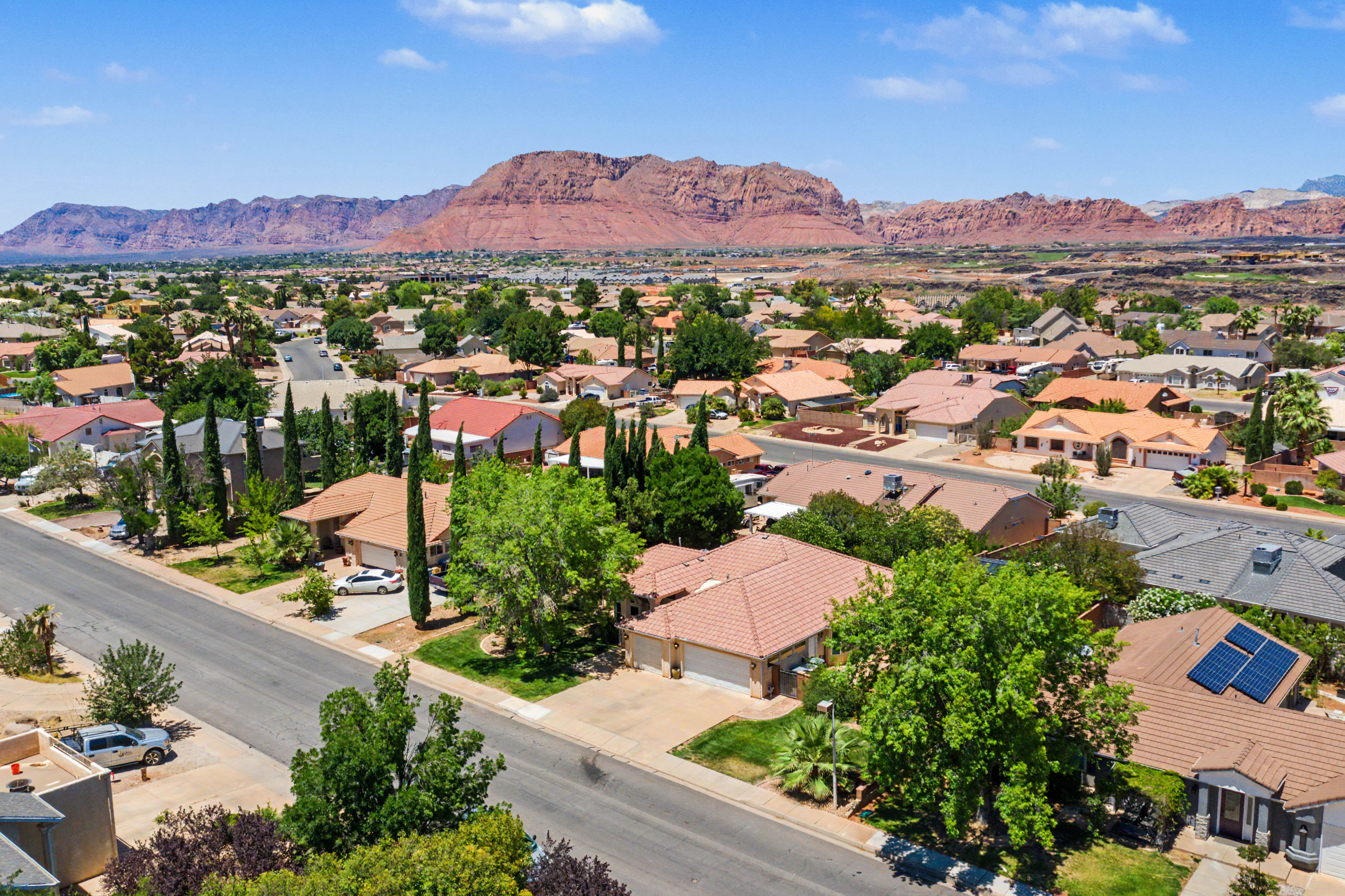 Residential neighborhood with a backdrop of red rock mountains and a clear sky