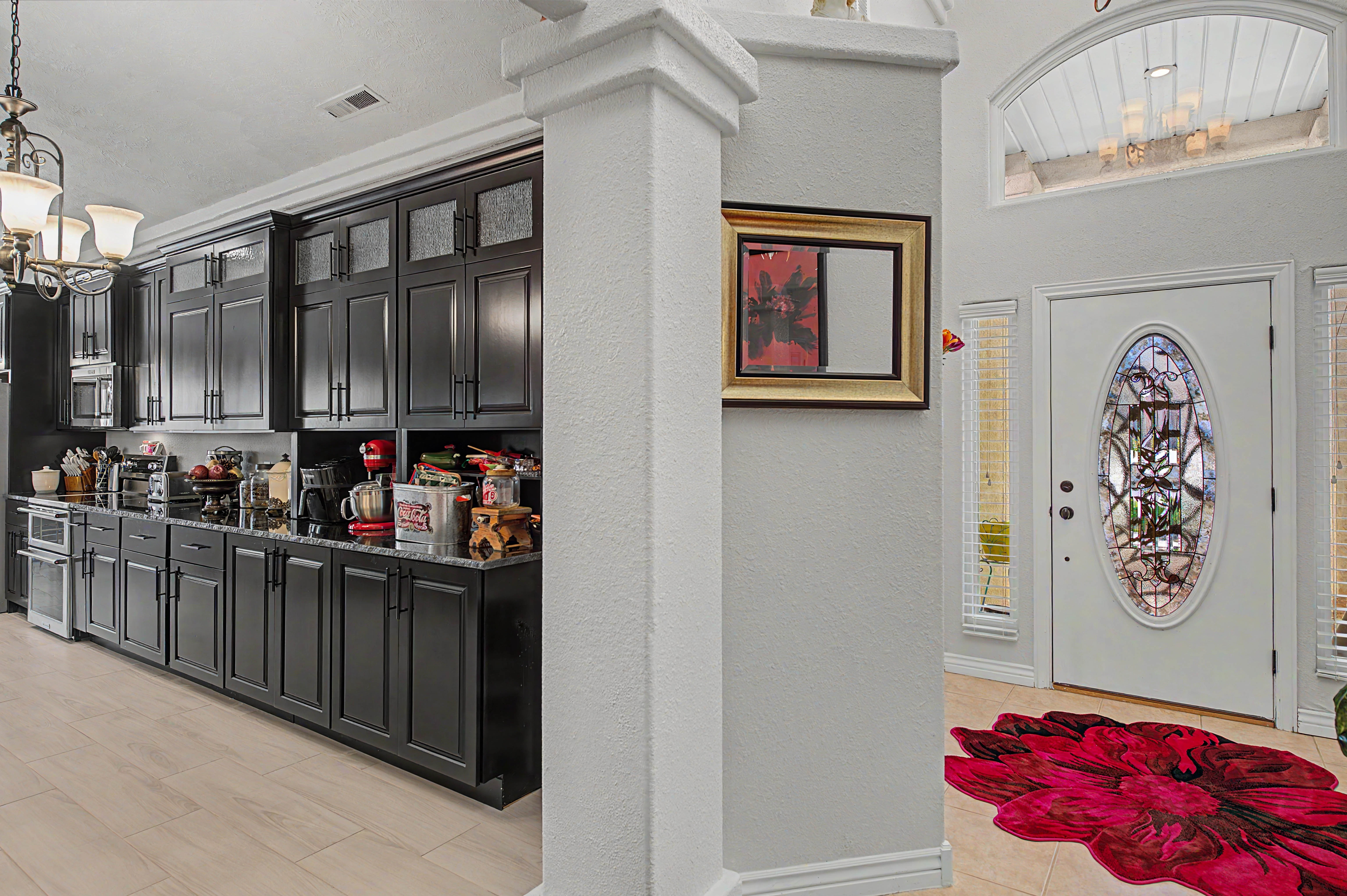 Entryway featuring a white door with an oval stained-glass insert, flanked by sidelight windows