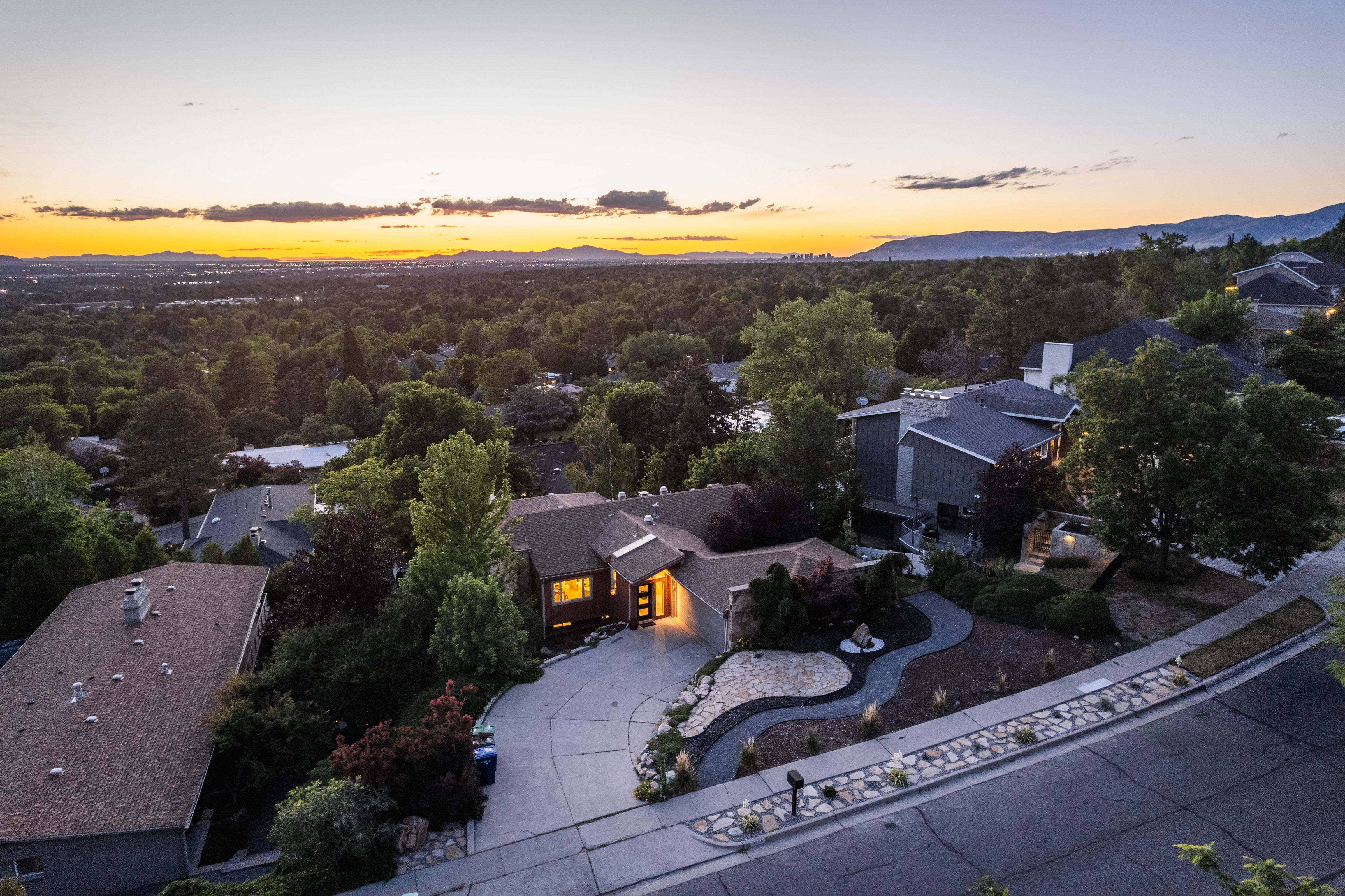 Contemporary residence featuring a multi-level roofline and a winding driveway