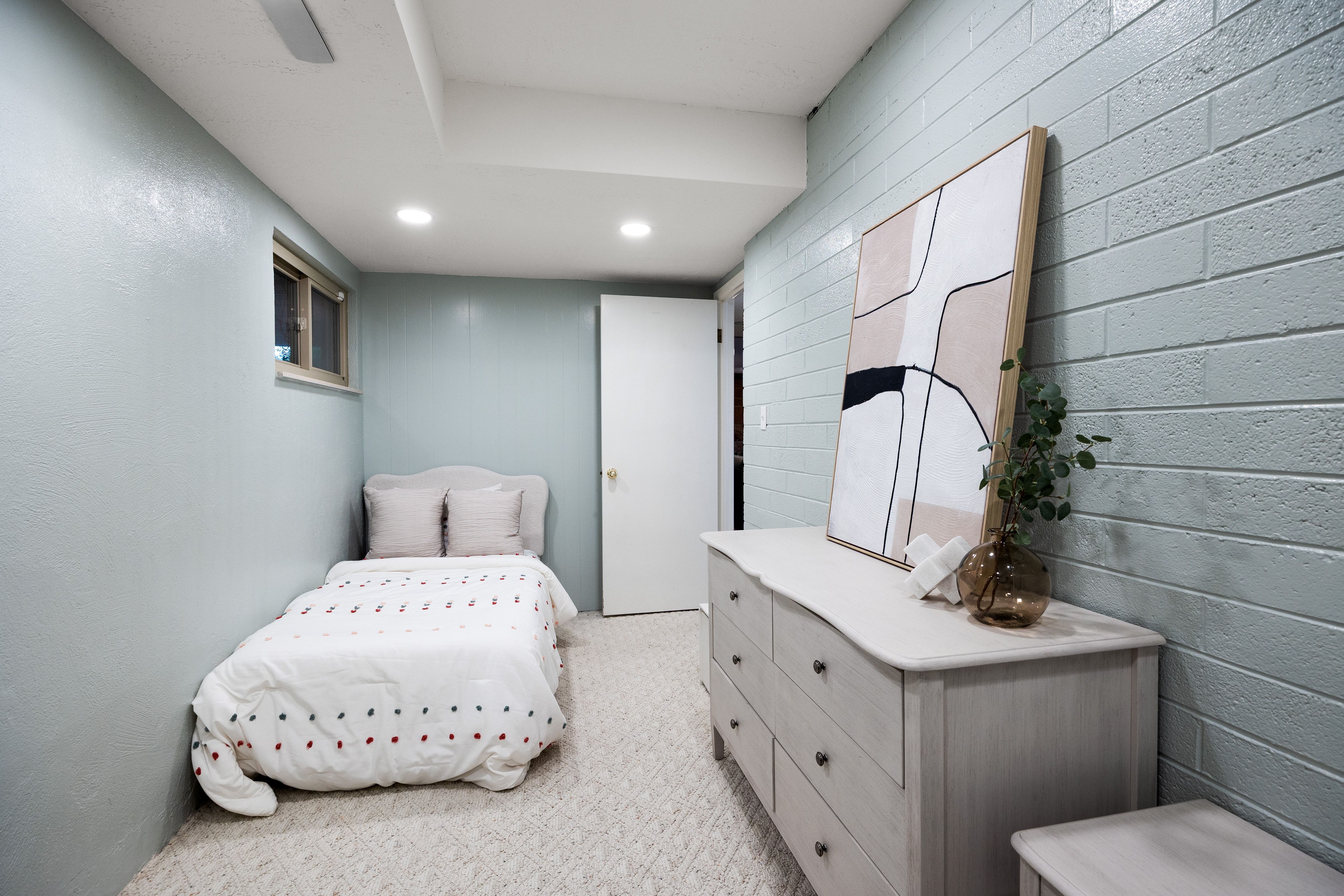 Room featuring light blue painted walls, one with a brick texture, and recessed ceiling lighting