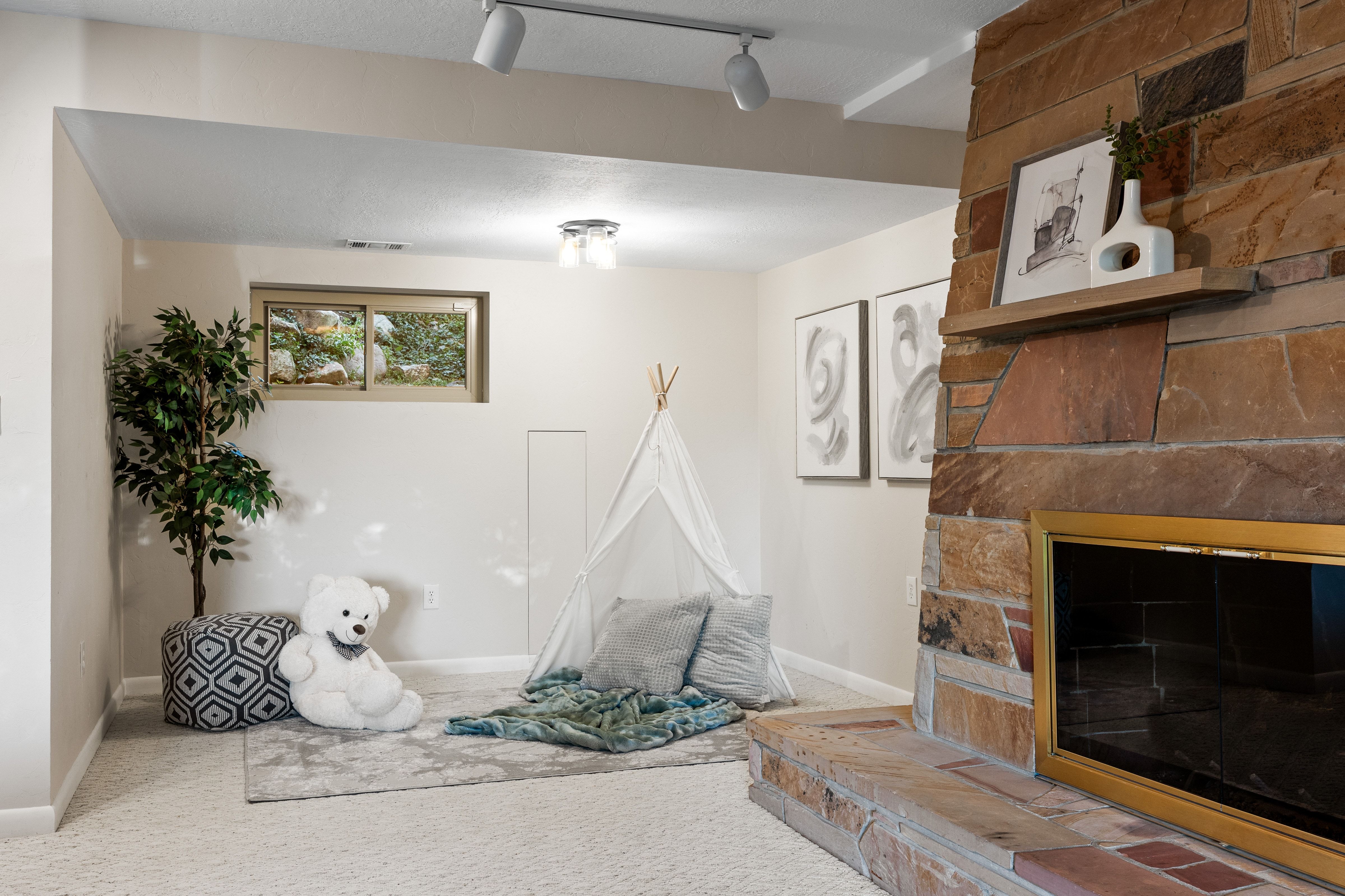 Stone-clad fireplace with a brass firebox surround and a wood mantel shelf