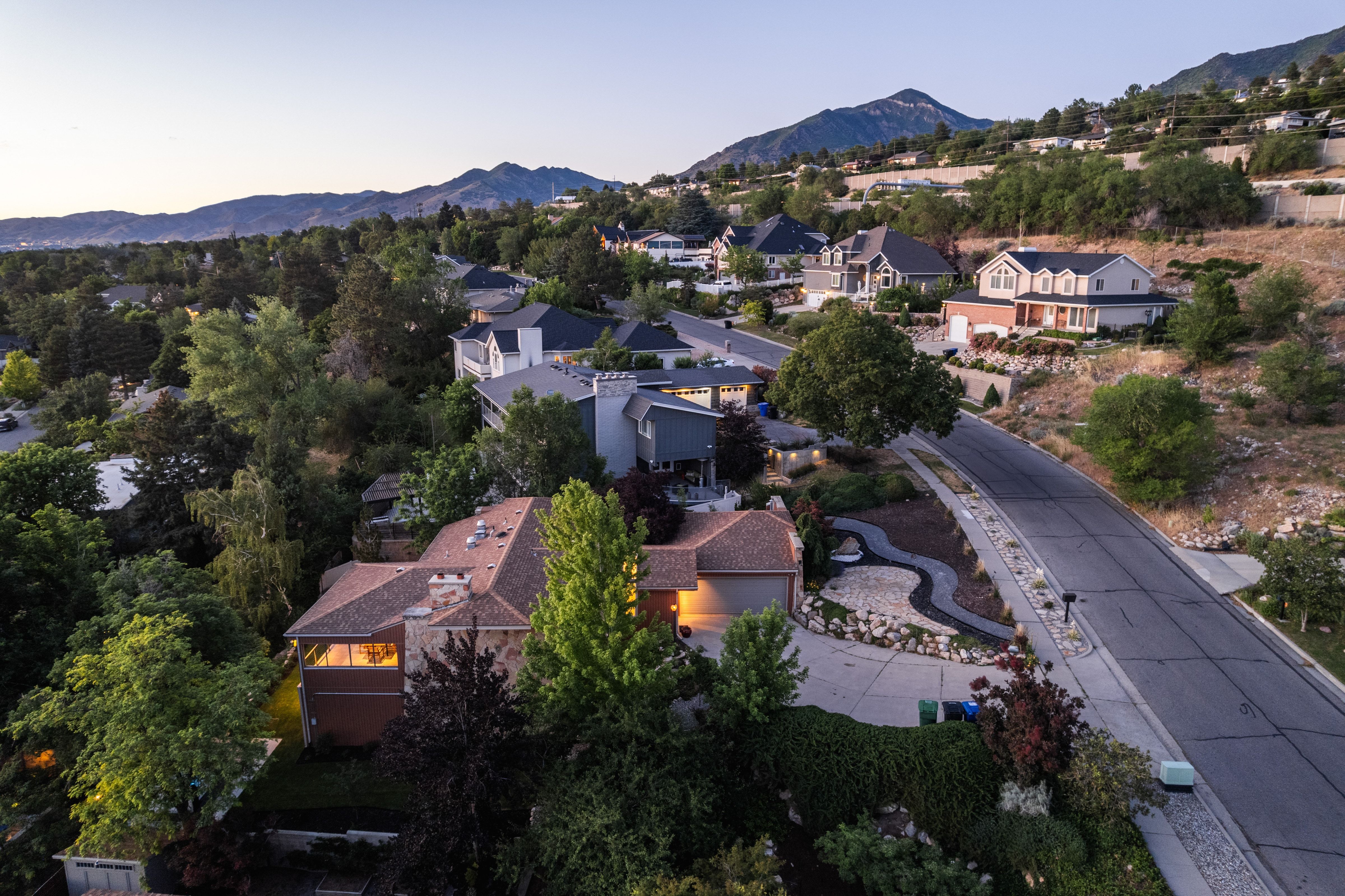 Contemporary multi-level residence featuring a prominent front-facing garage with a paved driveway