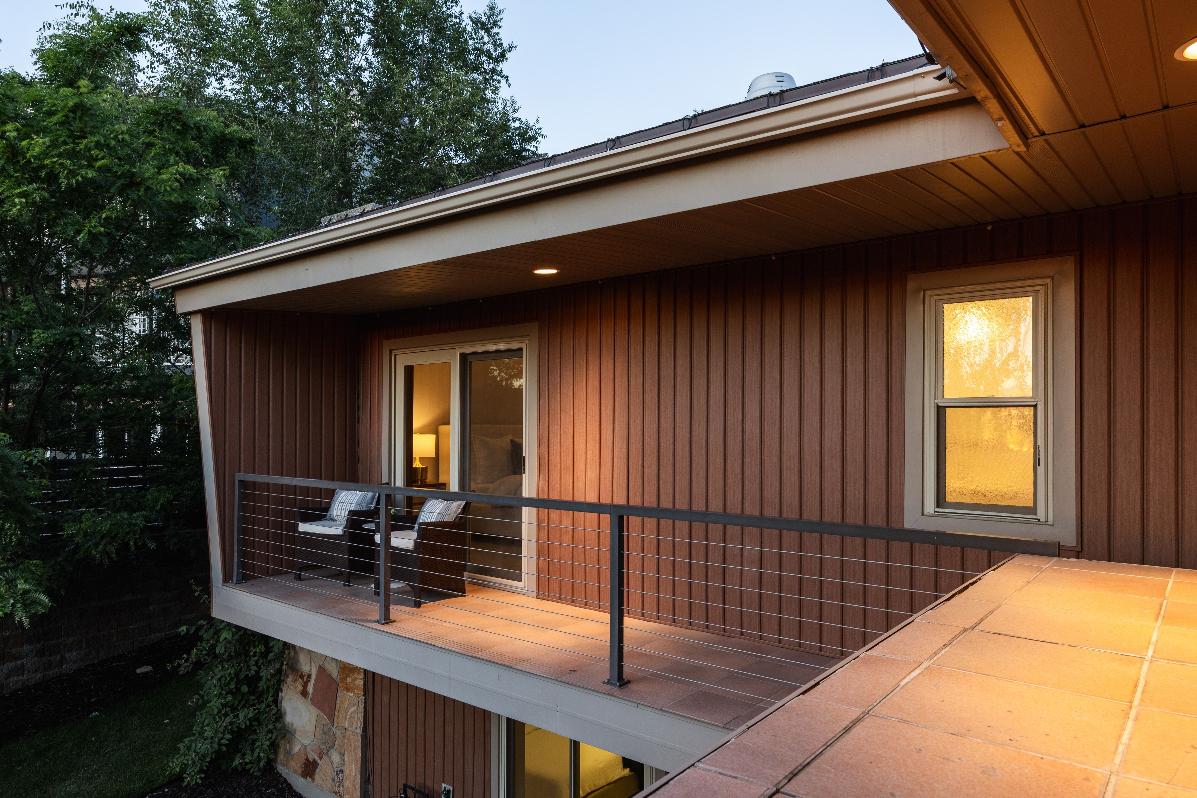 Balcony with wood-finish decking, cable railing, and recessed lighting