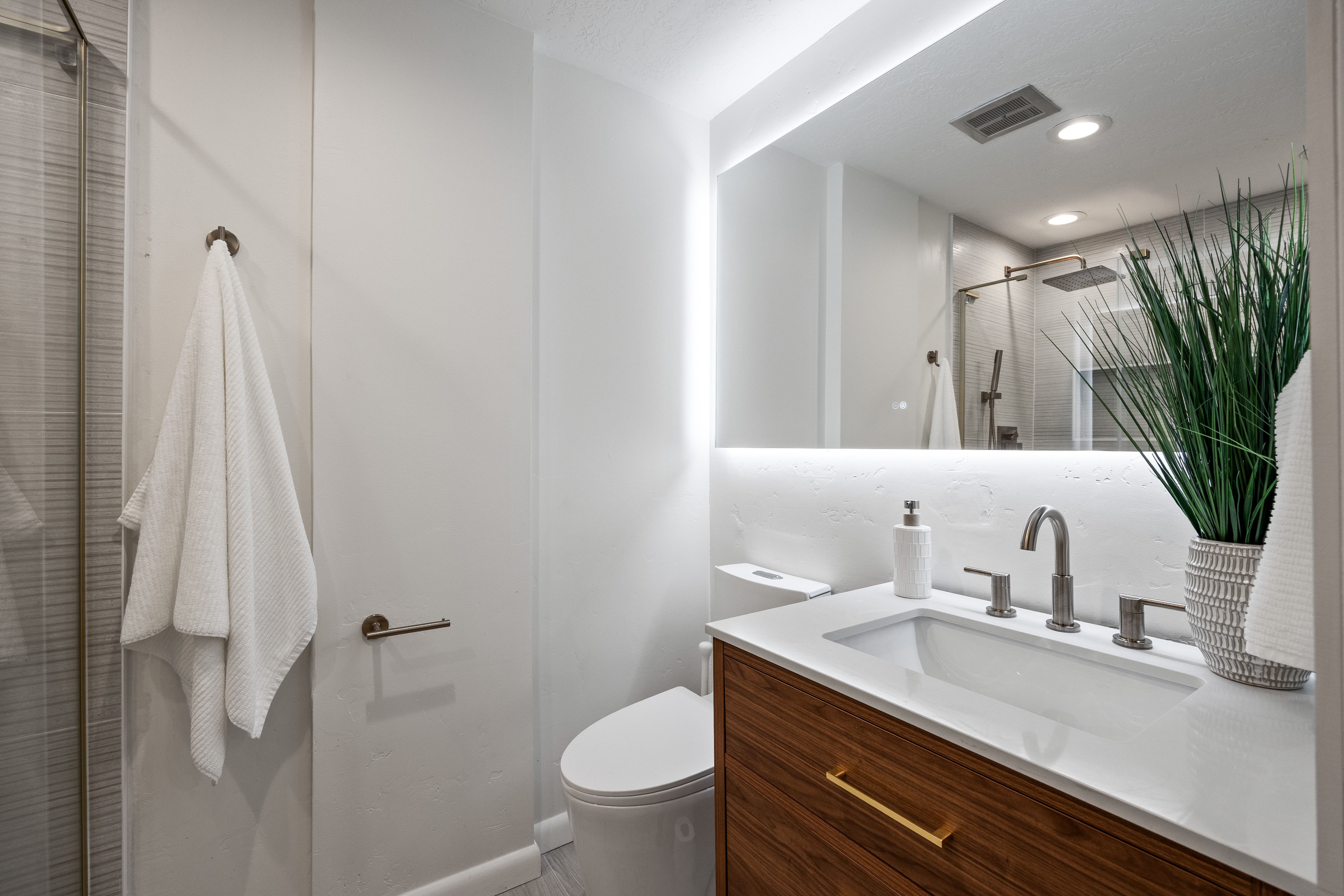 Modern bathroom featuring a wood-finish vanity with an integrated sink and brushed nickel faucet