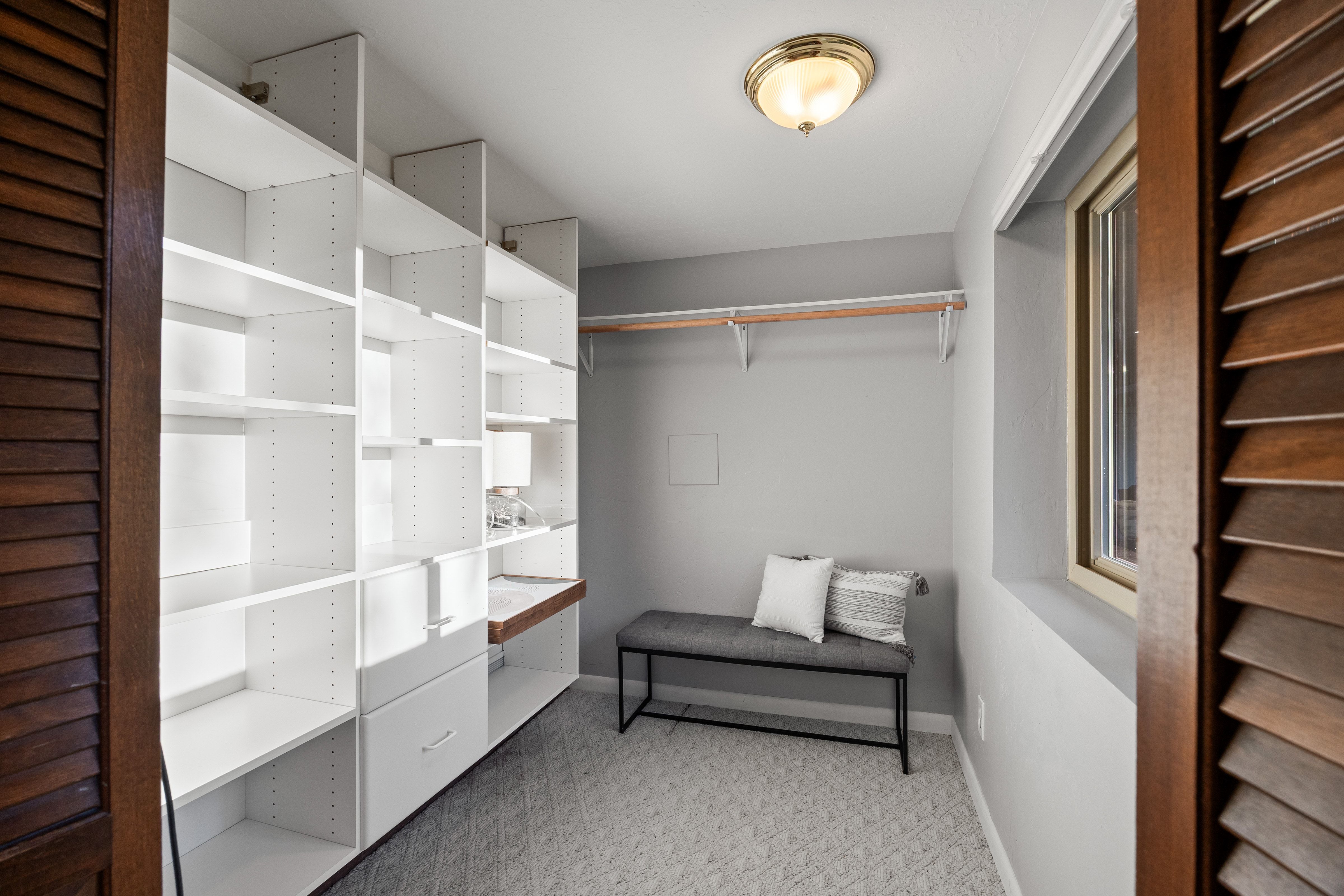 Custom closet system featuring extensive white shelving and integrated drawers