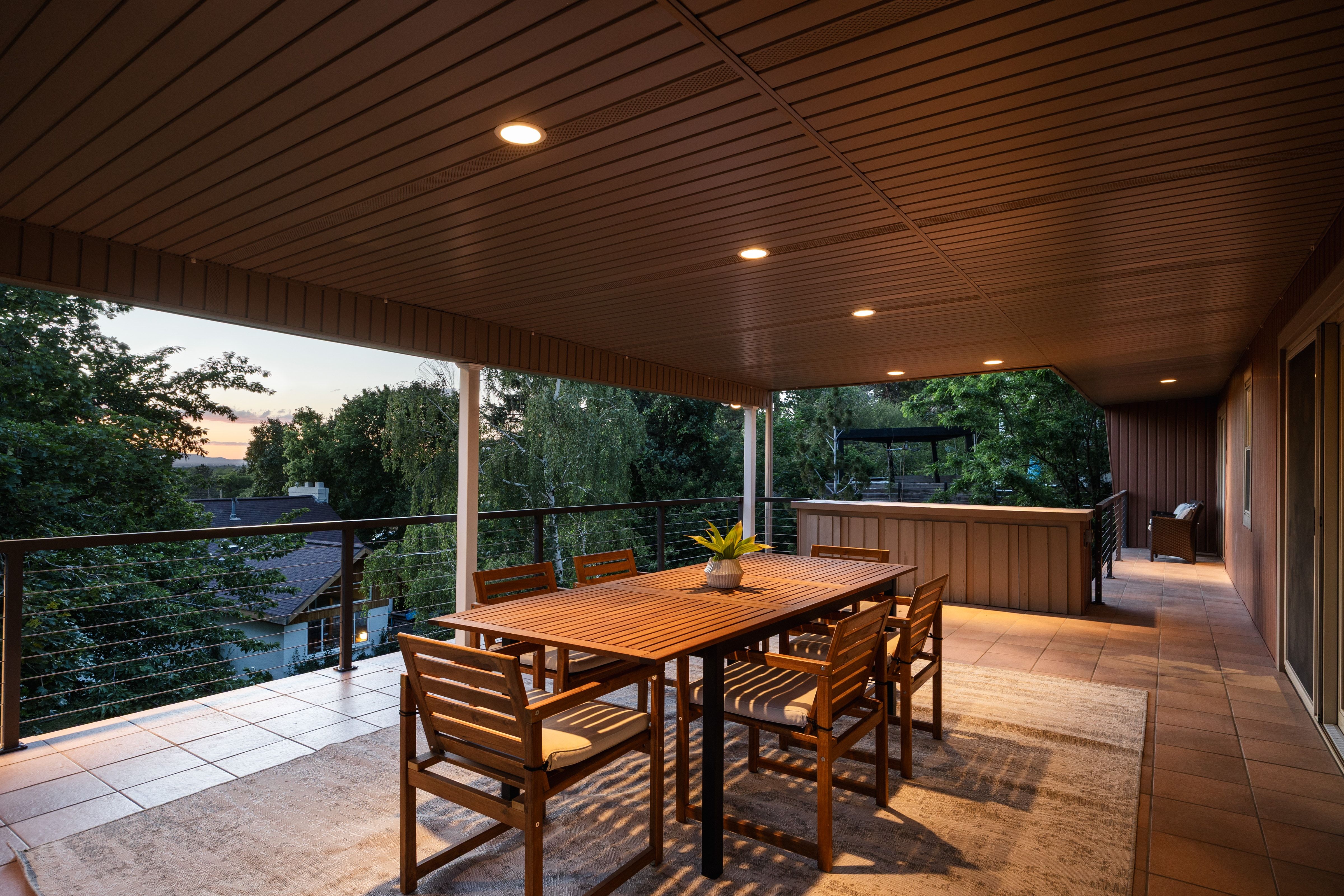Expansive covered patio featuring recessed lighting, a cable railing system, and a wood-paneled ceiling