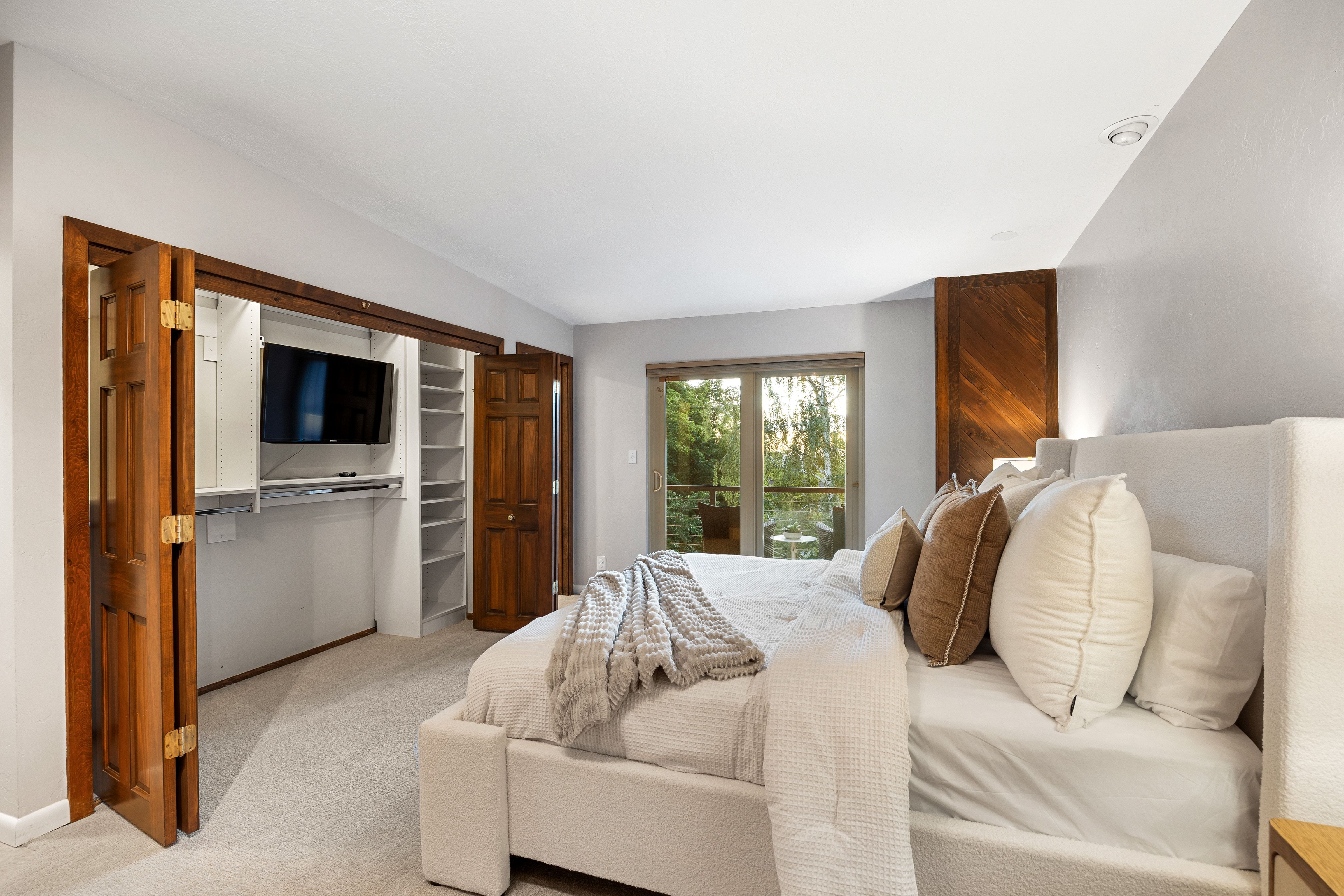 Carpeted room featuring a built-in closet with bi-fold wooden doors and shelving