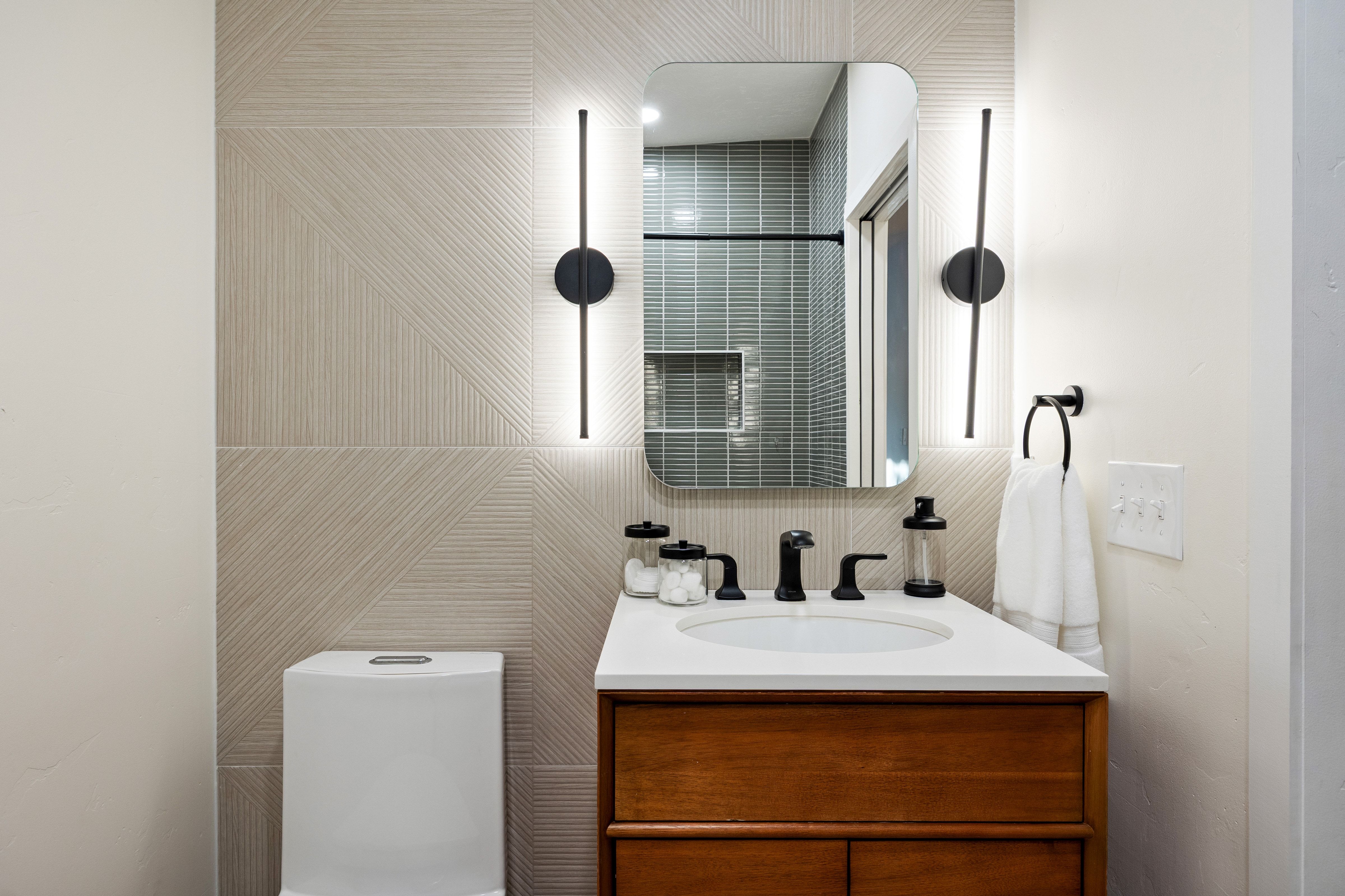 Bathroom vanity with a wood-finish cabinet, white countertop, and integrated sink
