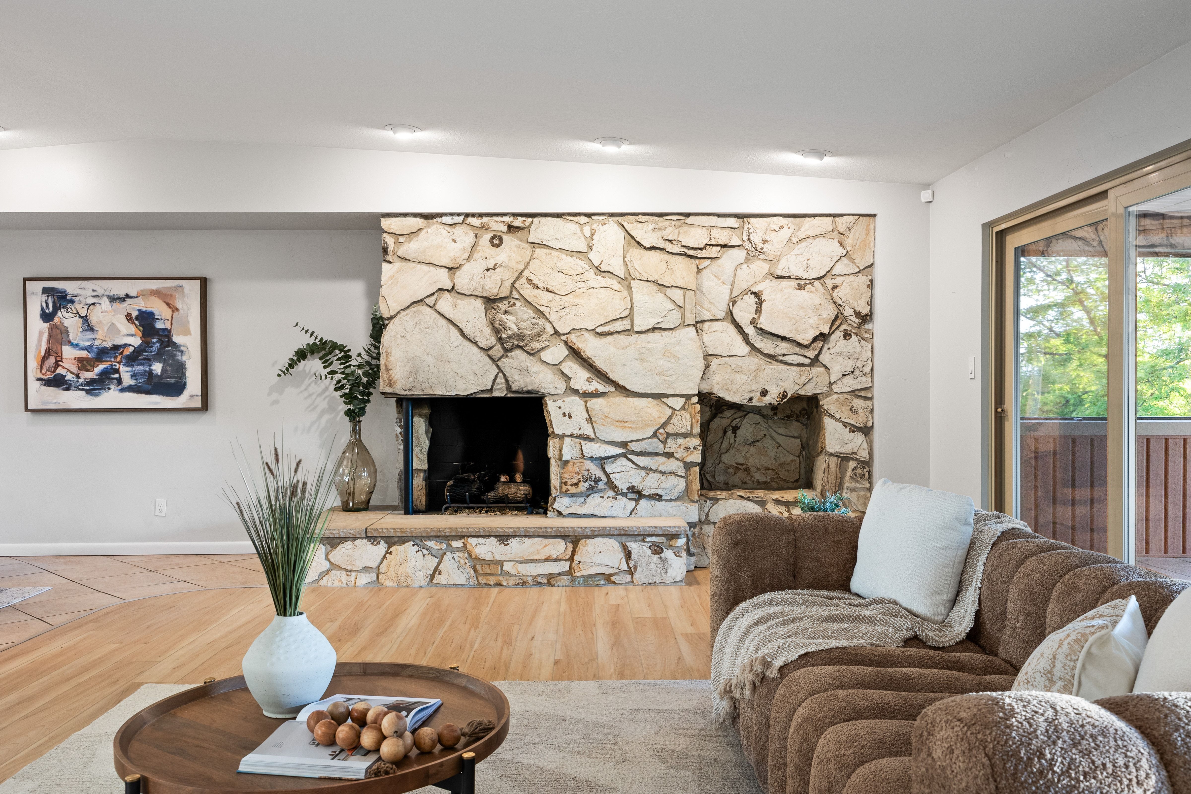 Floor-to-ceiling stone fireplace featuring a hearth and dual fireboxes