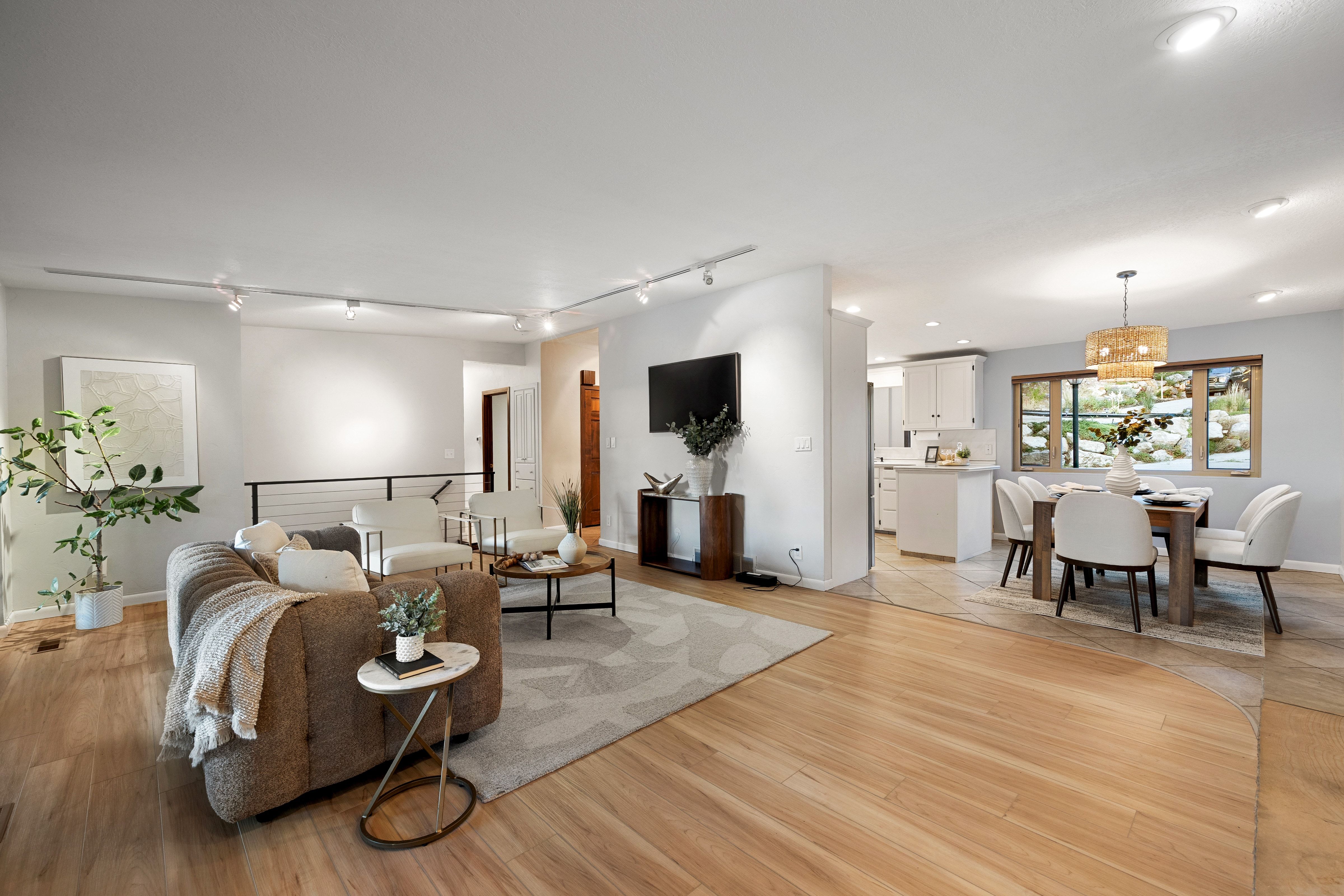Open-concept living space featuring wood-finish flooring, recessed lighting, and a modern track lighting system