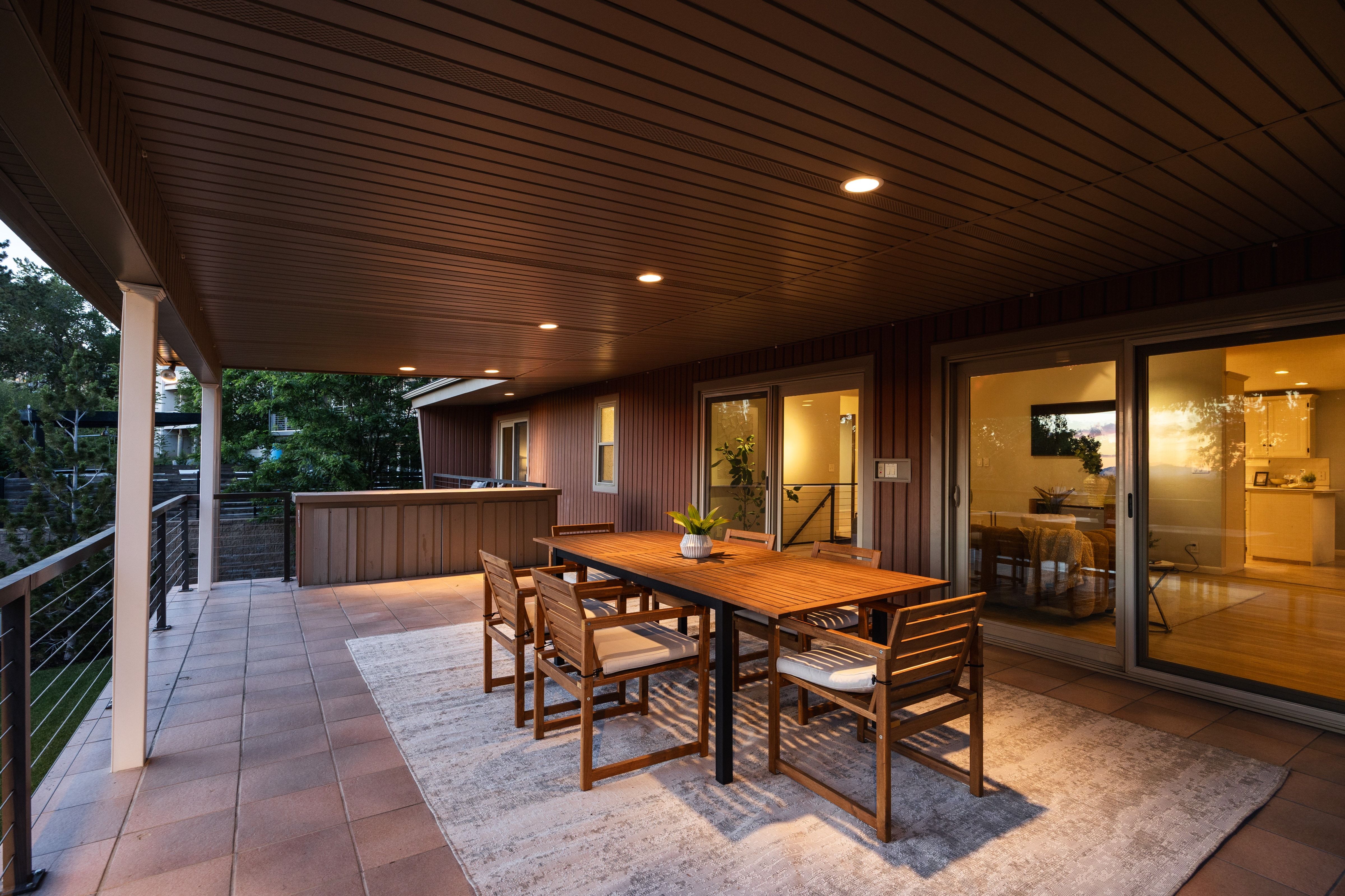 Expansive covered patio featuring paver flooring, recessed lighting, and a wood slat ceiling