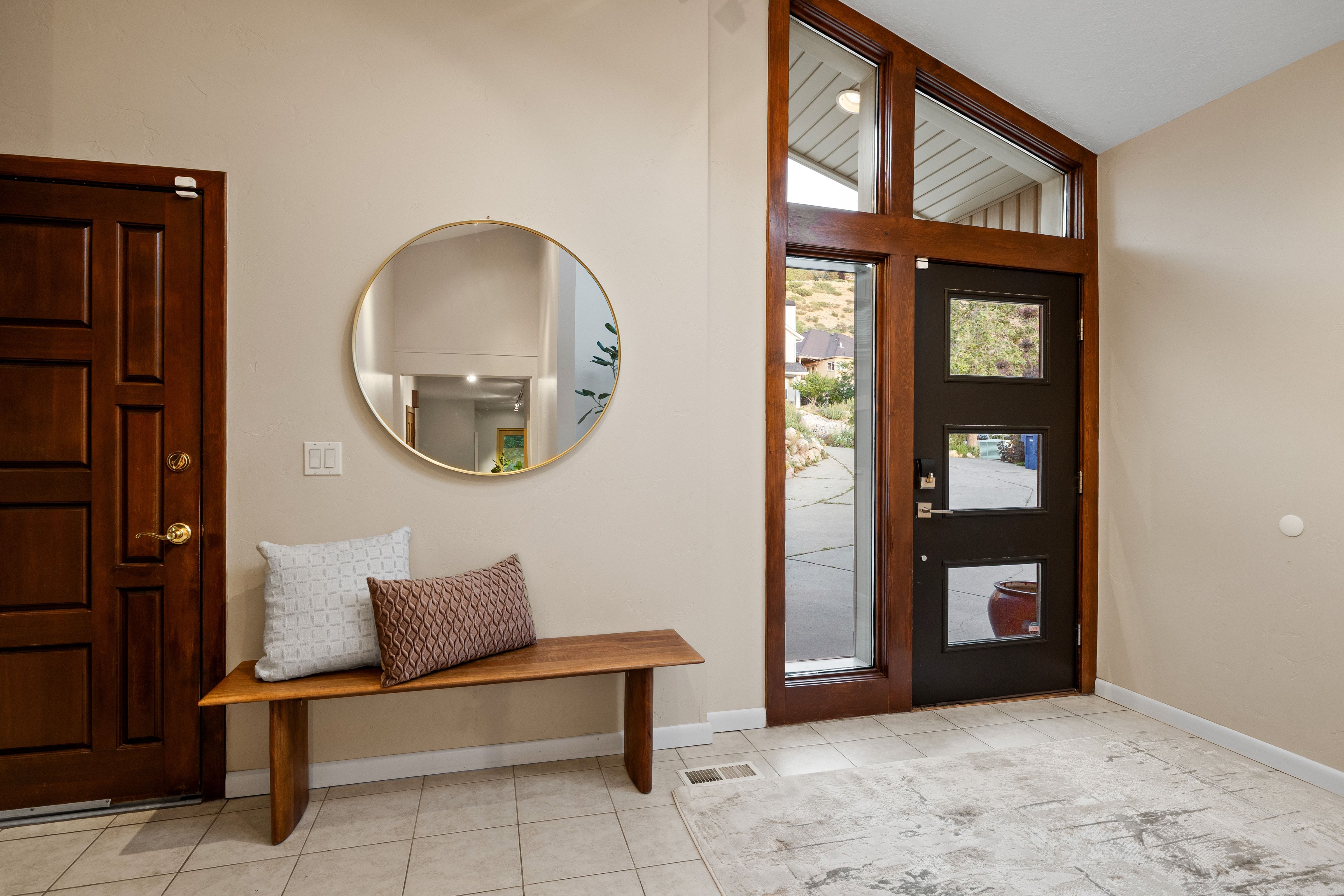 Foyer featuring a dark wood-finish entry door with multiple window panes, a large sidelight, and transom windows