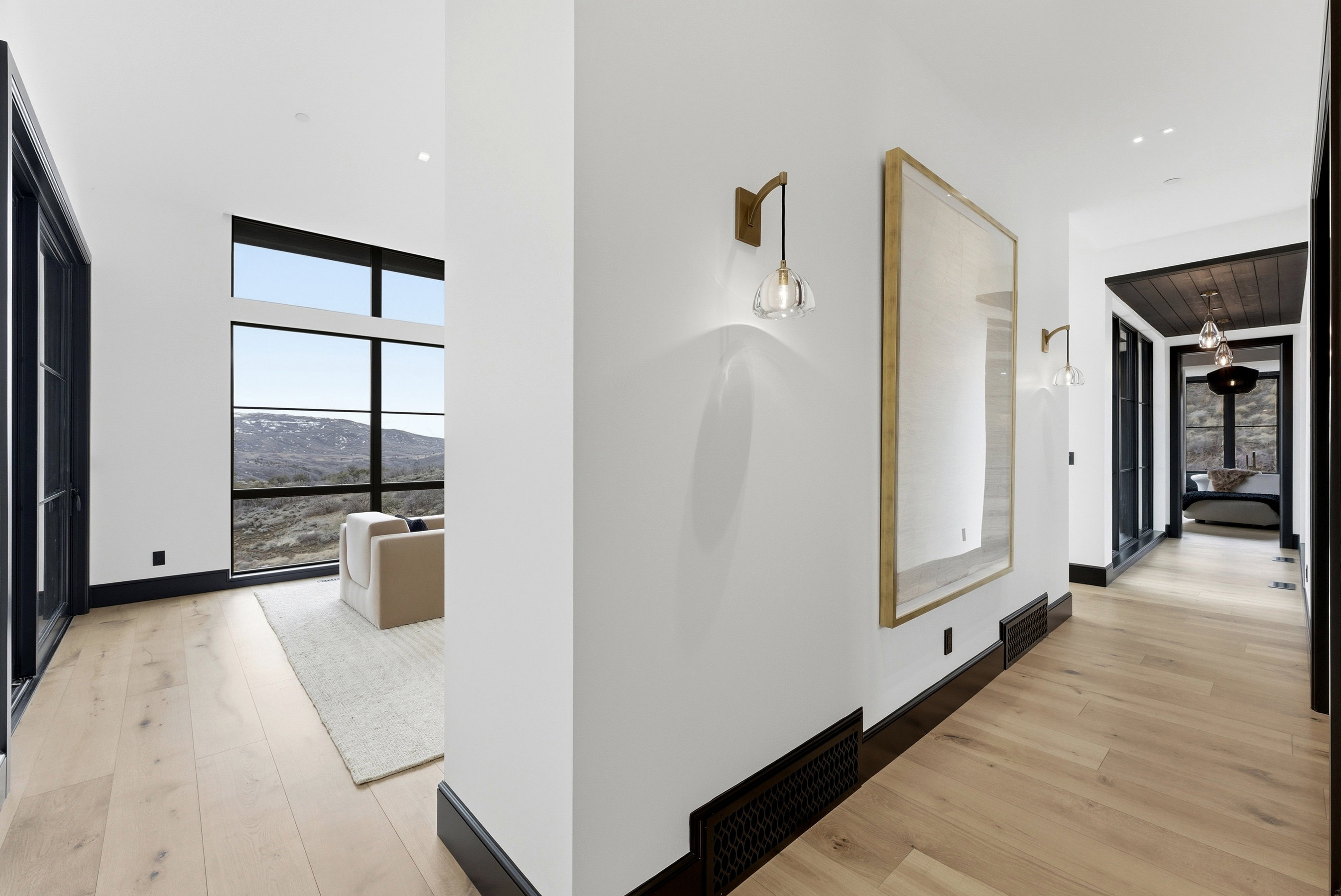 Wide plank wood-finish flooring throughout the hallway