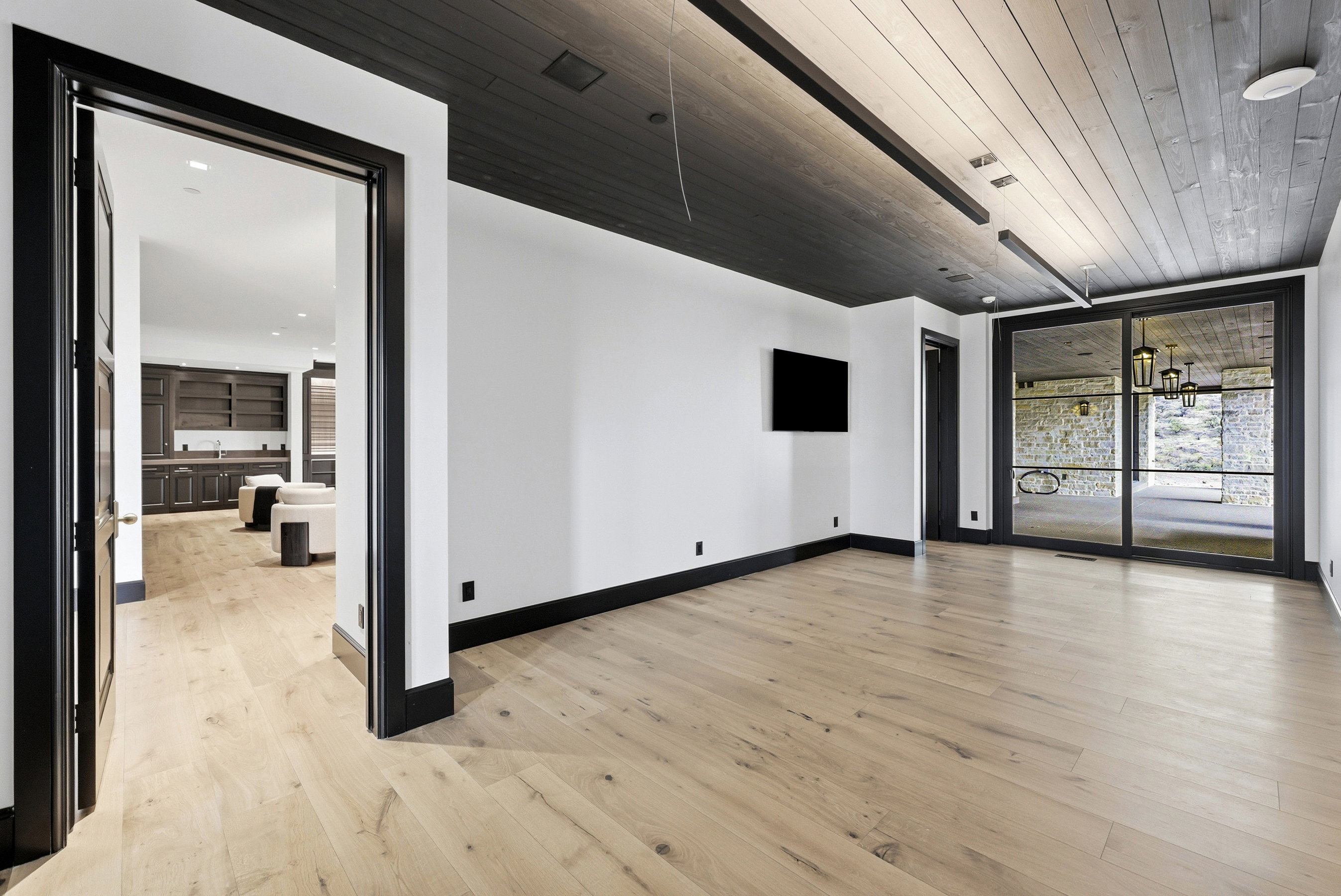Spacious interior featuring light wood-finish flooring, white walls, and dark trim