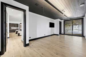 Spacious interior featuring light wood-finish flooring, white walls, and dark trim