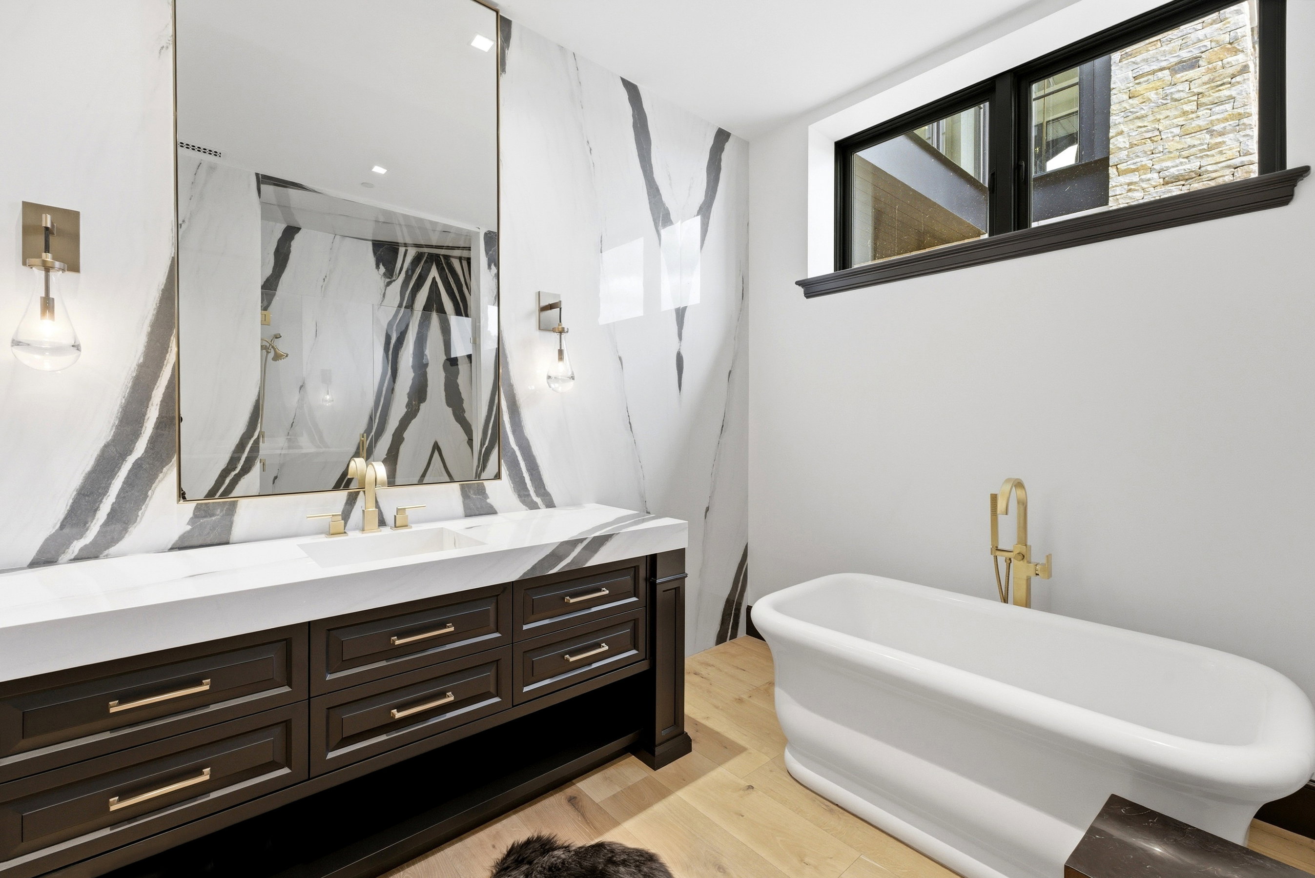 Bathroom featuring a floating dark wood vanity with ample storage, a white countertop, and a large wall-mounted mirror