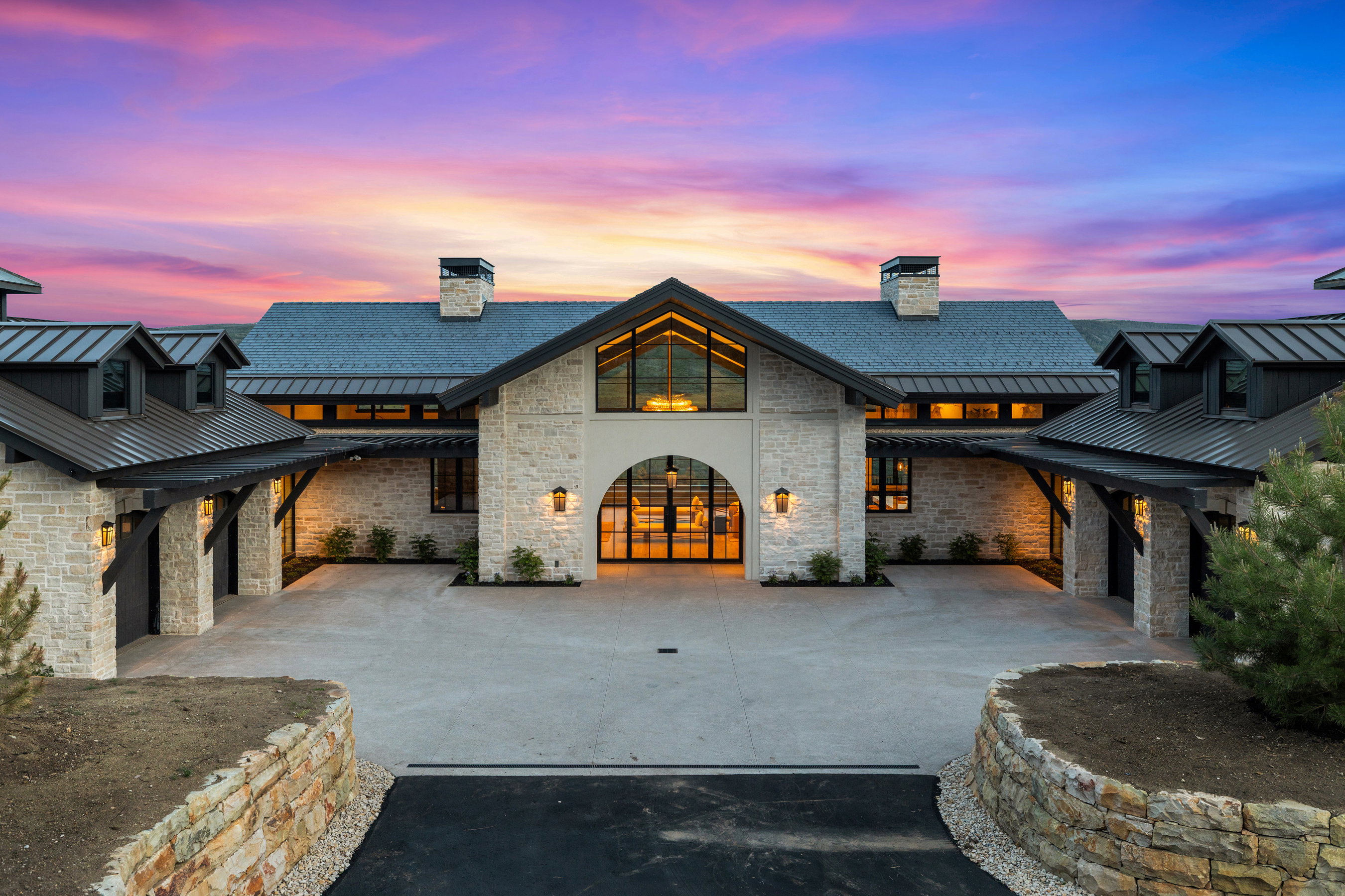Stone masonry exterior with a gabled roofline and black metal roofing