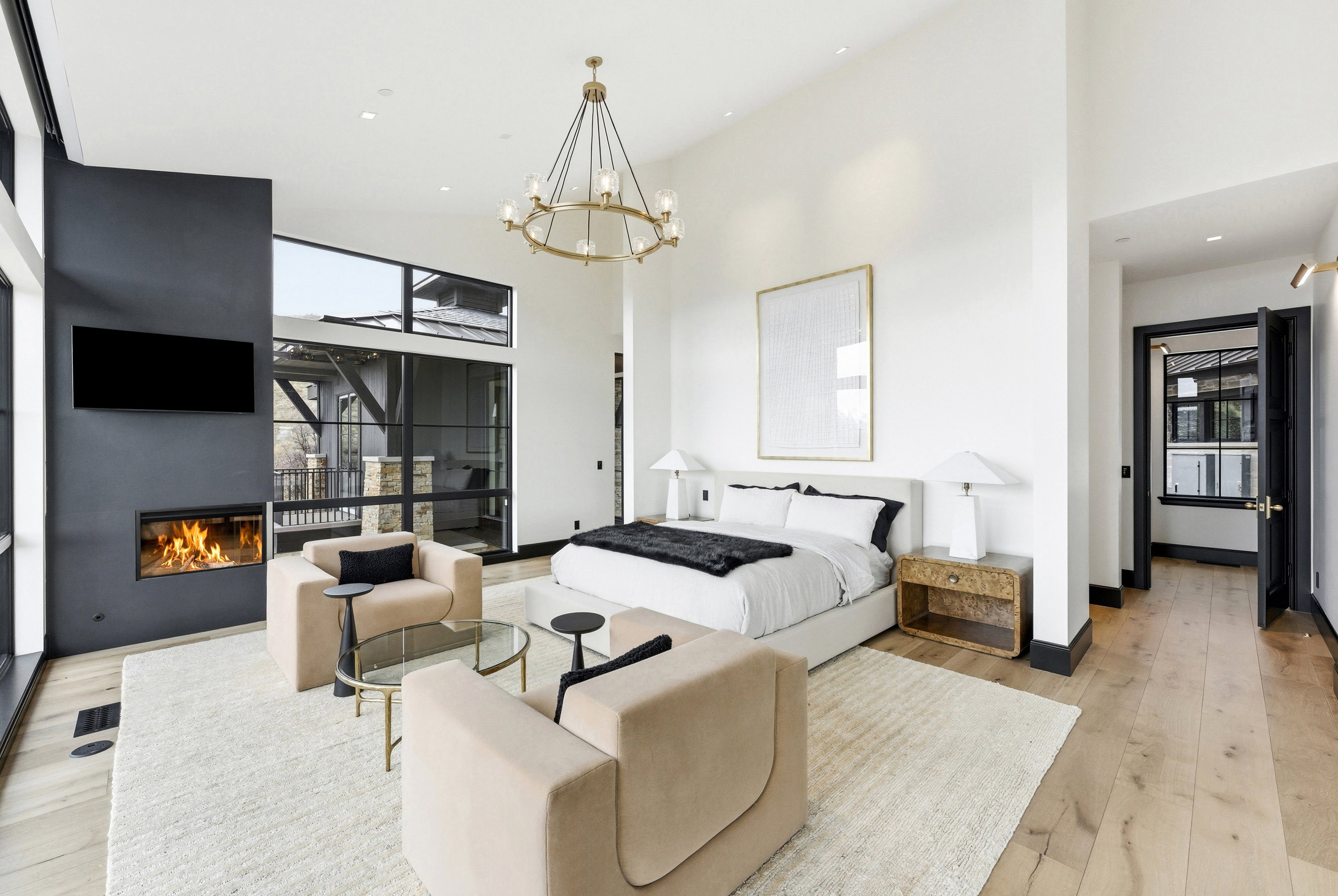 Expansive room featuring light wood-finish flooring, a contemporary fireplace, and a large window wall