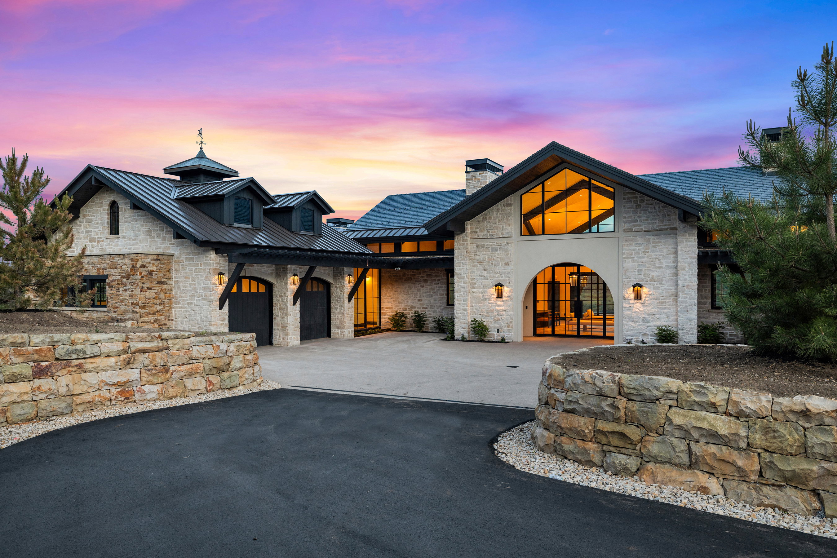 Stone-clad exterior with a prominent arched entry and expansive window features