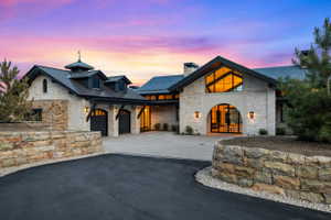 Stone-clad exterior with a prominent arched entry and expansive window features