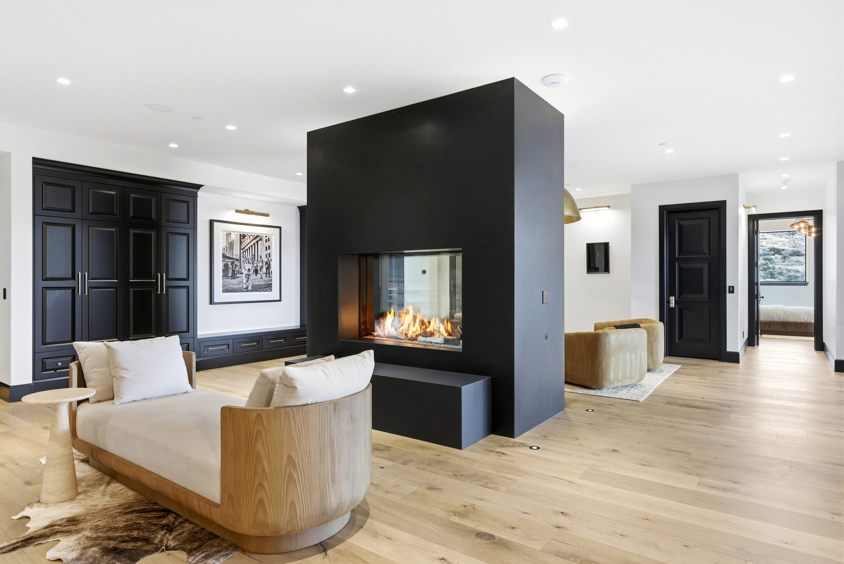 Freestanding black fireplace with a glass-encased flame feature
