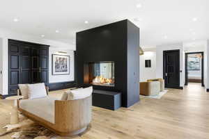 Freestanding black fireplace with a glass-encased flame feature