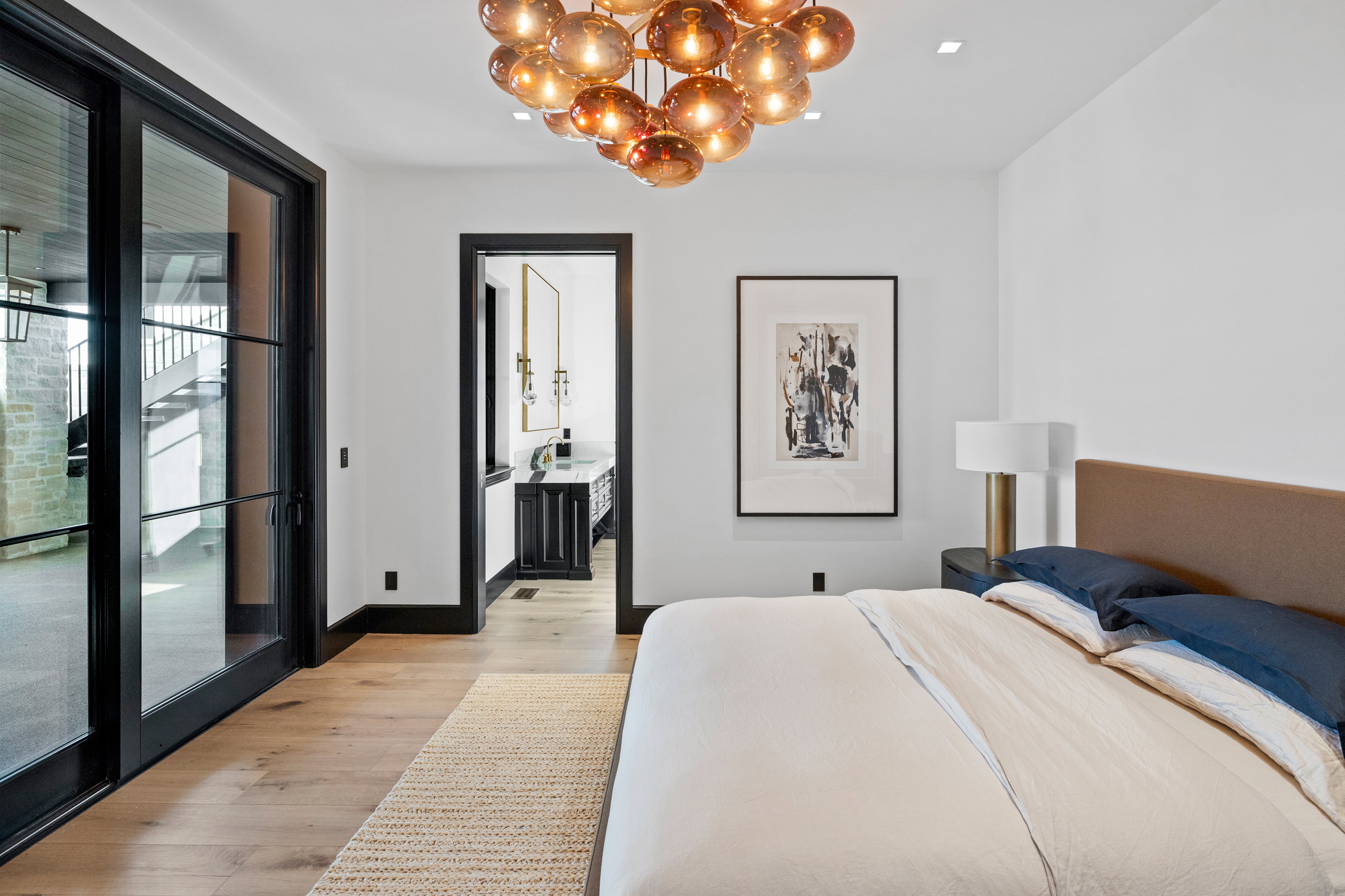 Bright bedroom featuring wood-finish flooring, a contemporary chandelier, and a recessed ceiling light
