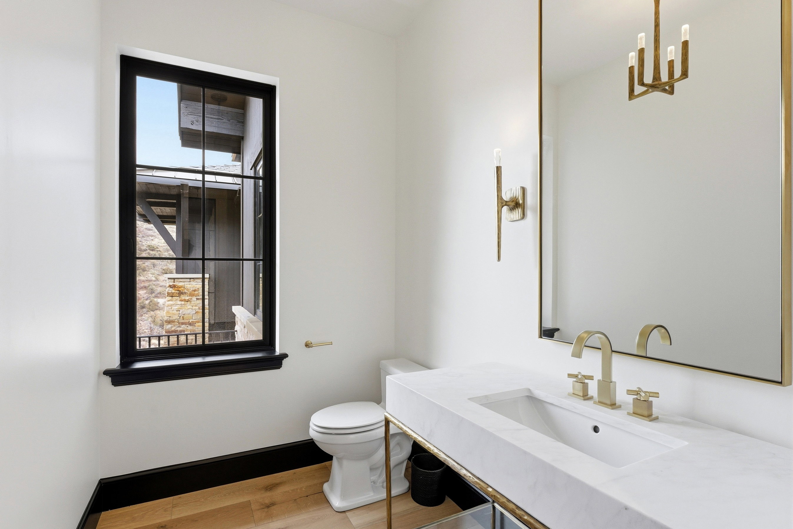 Bathroom featuring a black-framed window, light wood-finish flooring, and a white vanity with an integrated sink
