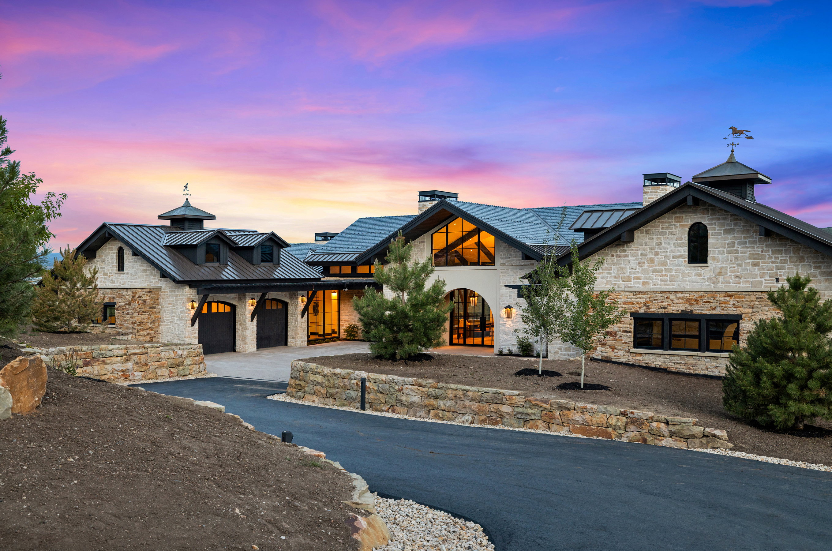 Stone and stucco exterior with multiple gables and a metal roof