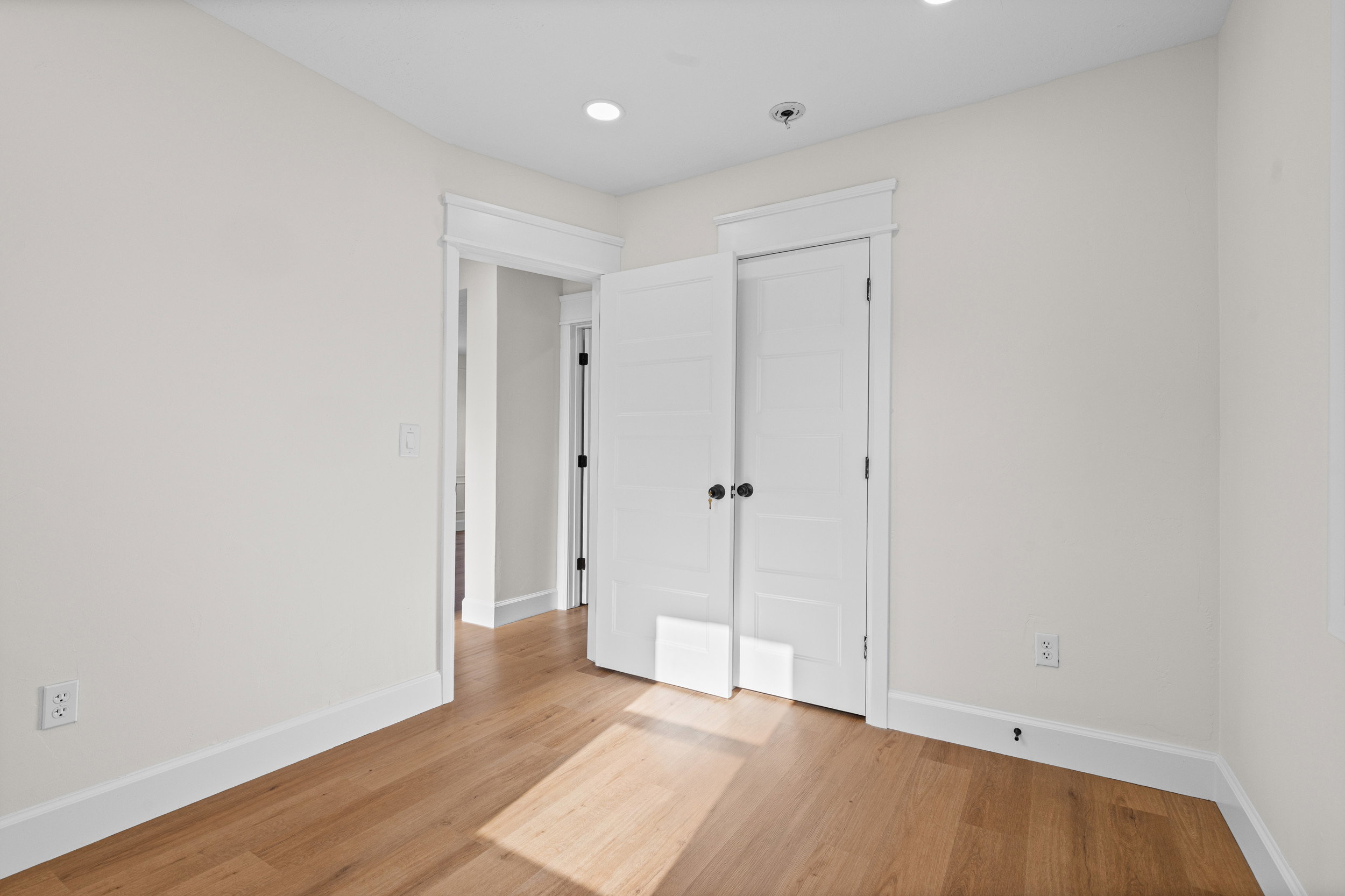 Light wood-finish flooring complemented by white trim and neutral wall tones