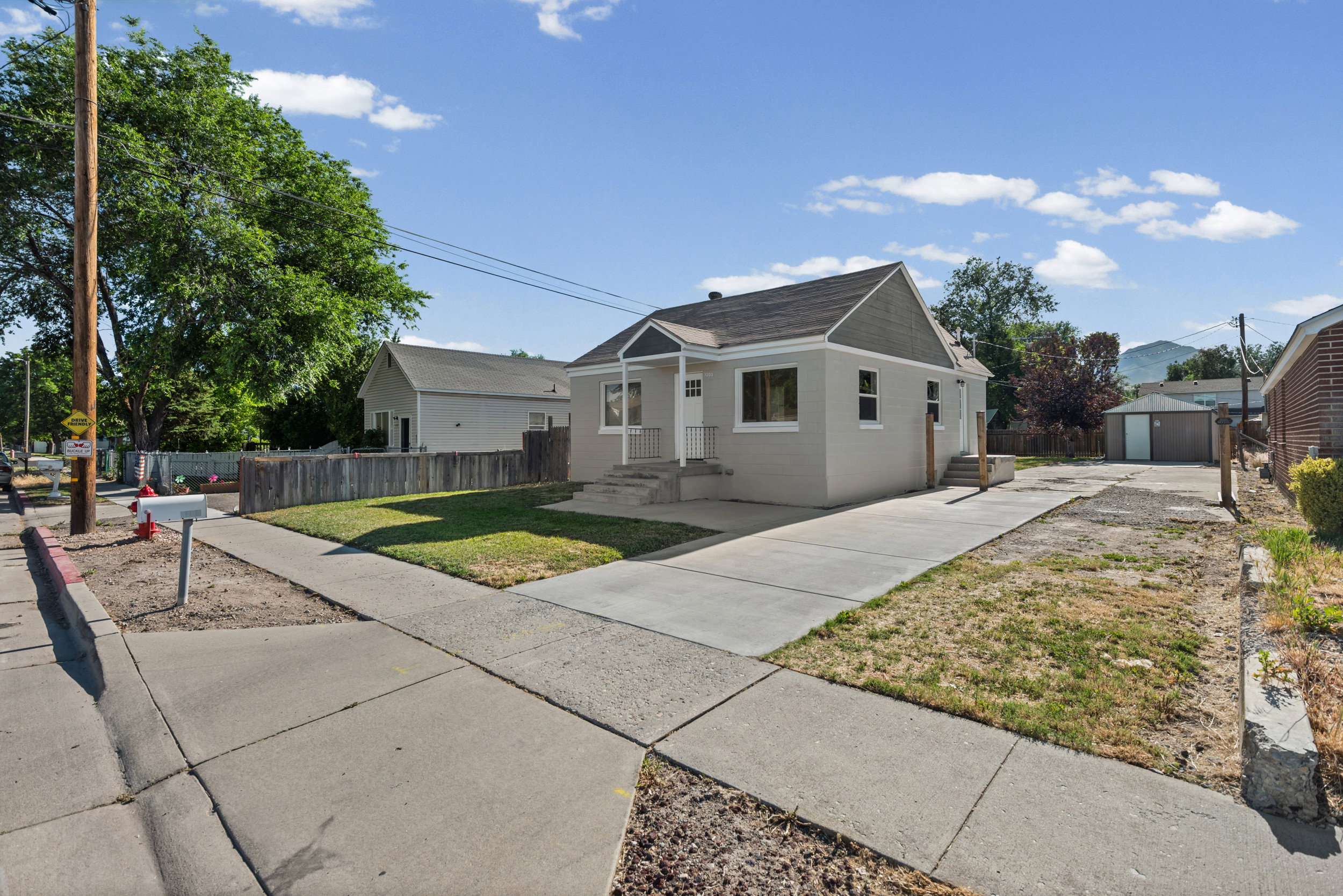 Single-story residence featuring a gray exterior and a gabled roofline