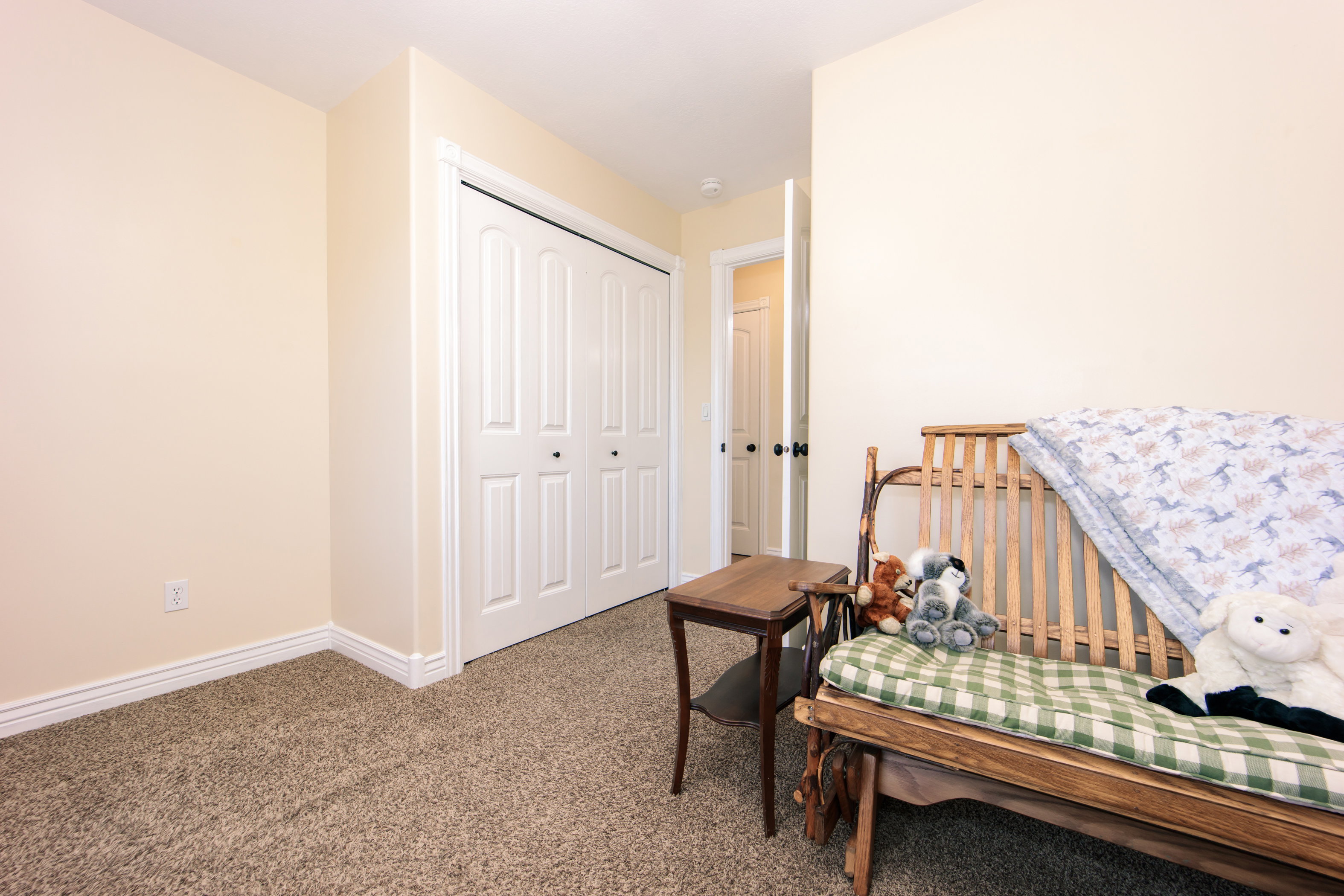 Neutral-toned interior room featuring light-colored walls and textured carpeting