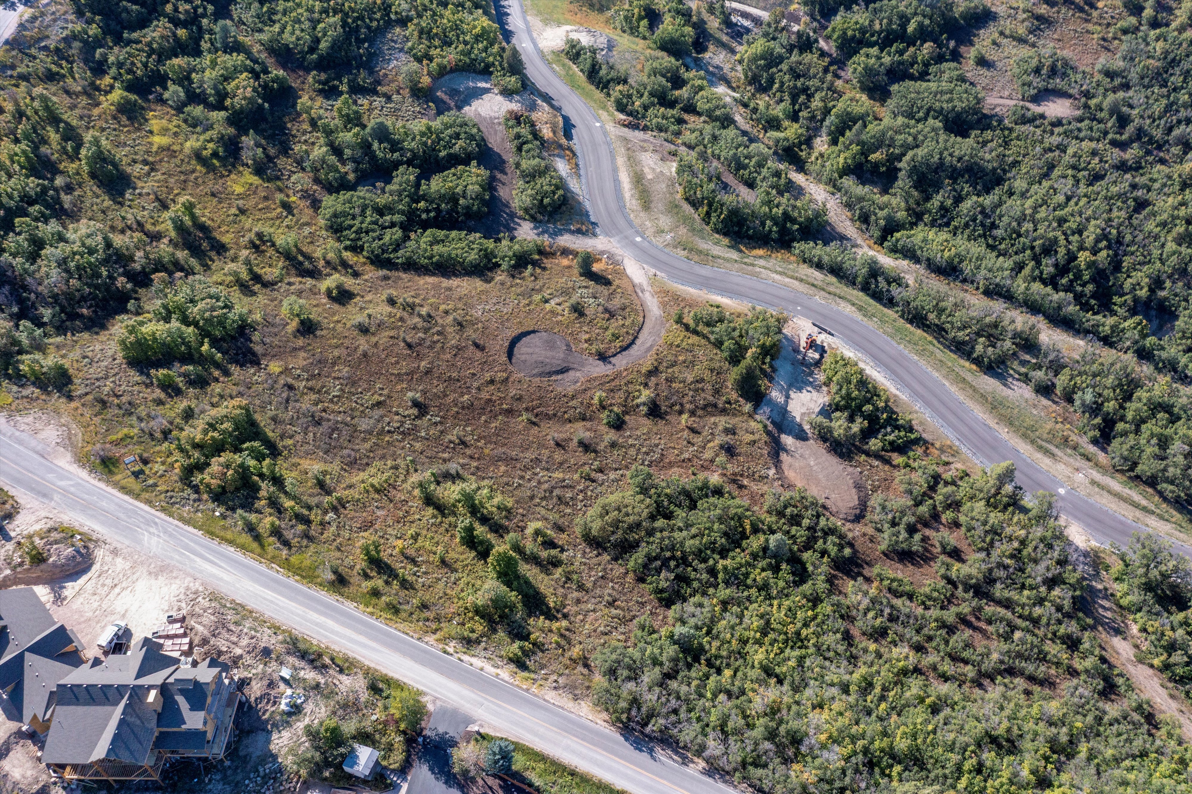 Expansive undeveloped land featuring natural terrain with scattered trees and shrubs