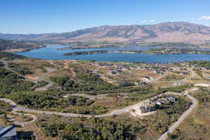 Expansive development with winding paved roads and multiple residential structures, offering distant lake and mountain scenery