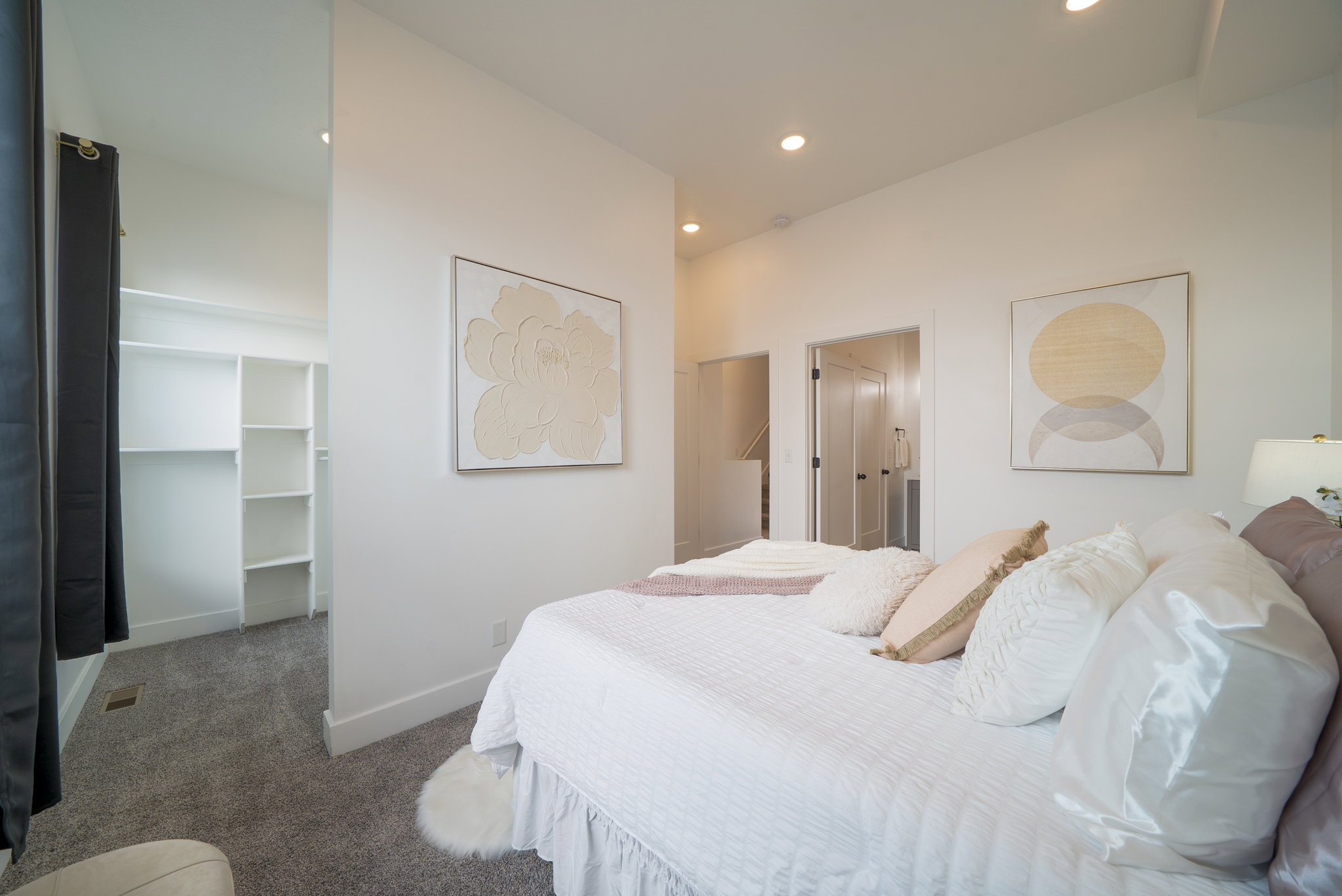 Bedroom featuring recessed lighting, a walk-in closet with built-in shelving, two interior doorways, and neutral wall tones