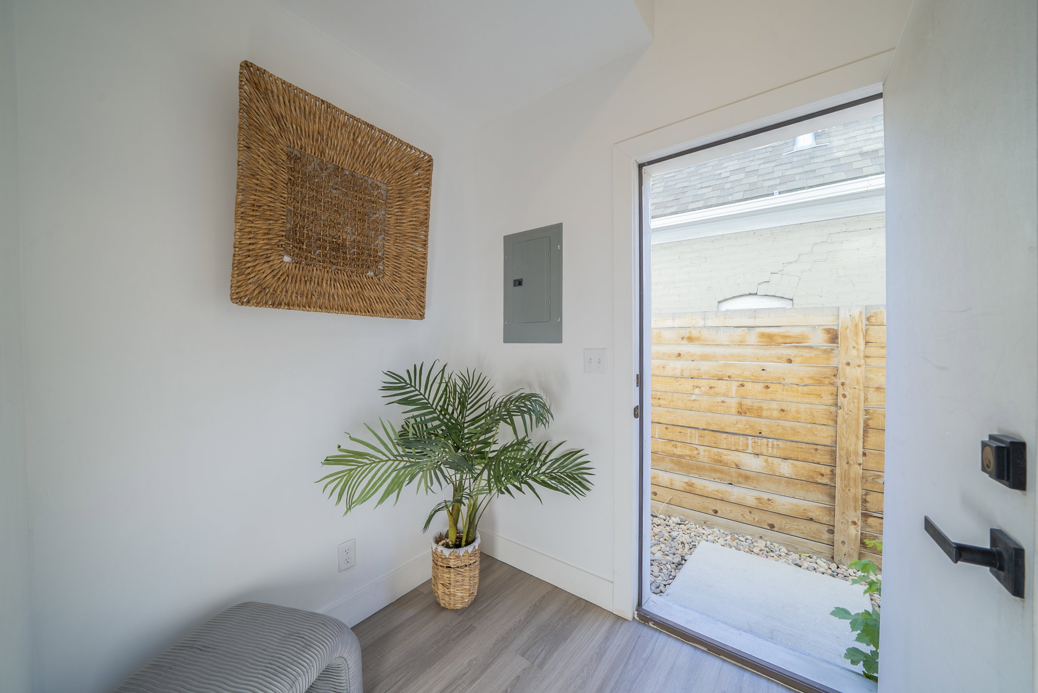 Entryway featuring wood-finish flooring, white walls, and a glass-paneled door with black hardware