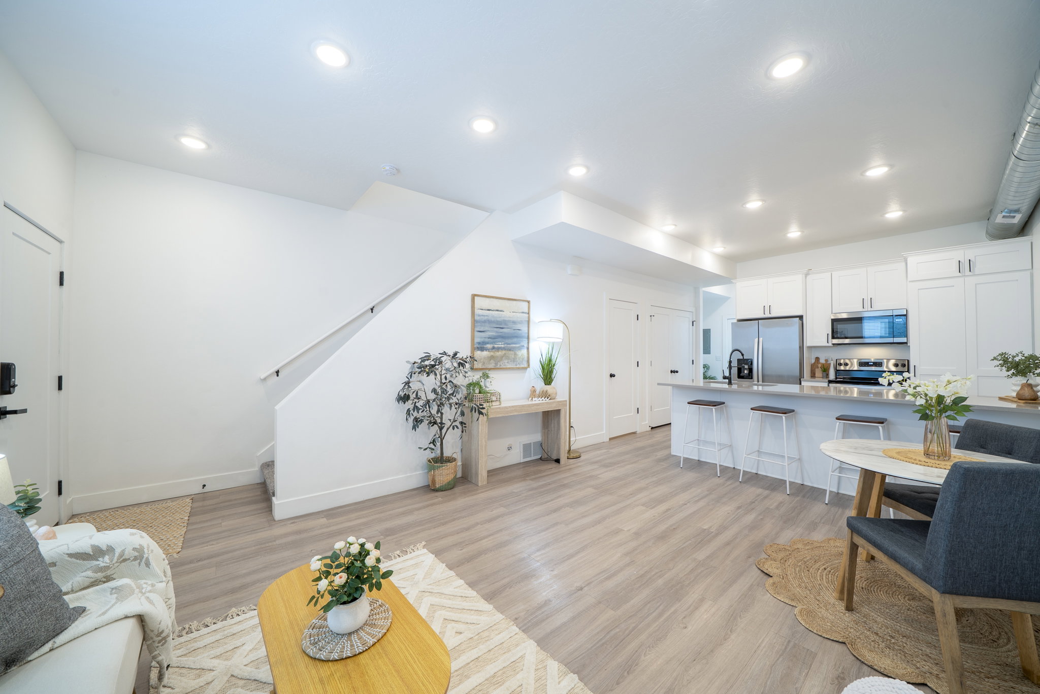 Open-concept living space featuring wood-finish flooring, recessed lighting, and a contemporary kitchen