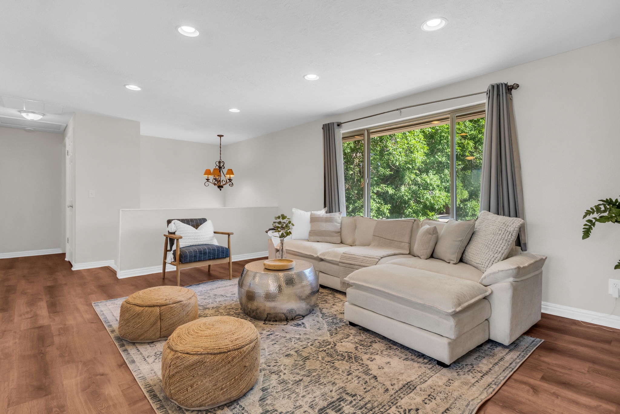Spacious living area featuring wood-finish flooring, recessed lighting, and a chandelier