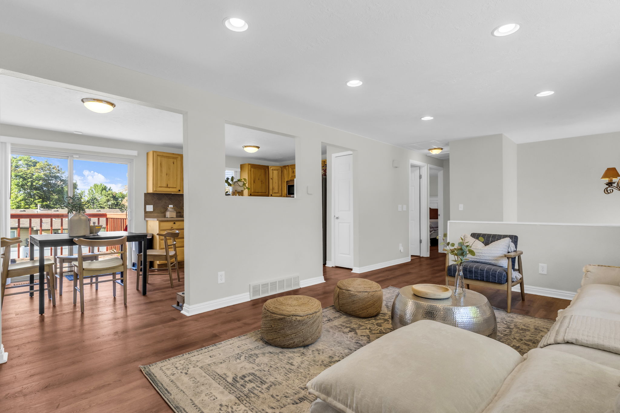 Open-concept living area featuring wood-finish flooring, recessed lighting, and a neutral color palette