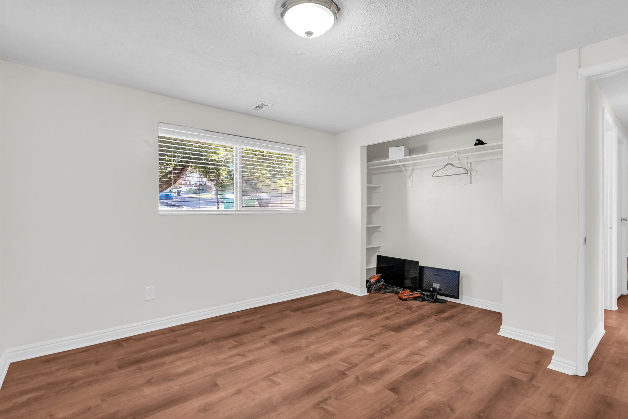Wood-finish flooring throughout, complemented by white baseboards