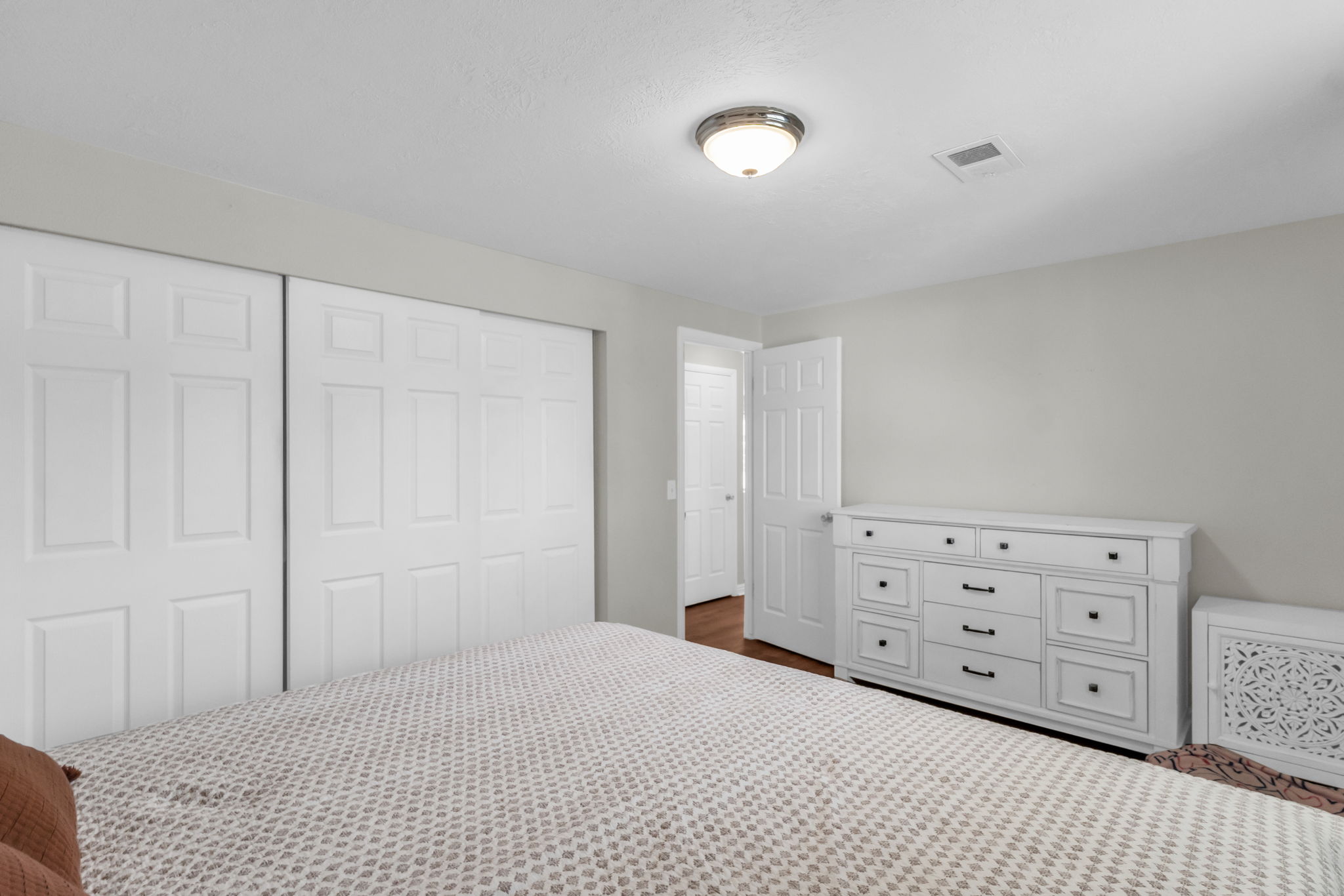 Bedroom featuring sliding panel closet doors, light gray wall paint, and a ceiling-mounted light fixture